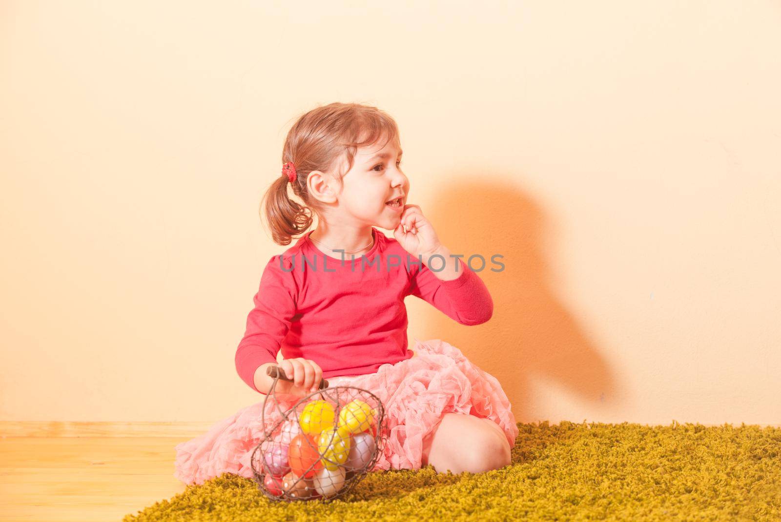 Kid gathers colorful eggs to the baskets on Easter Egg hunt