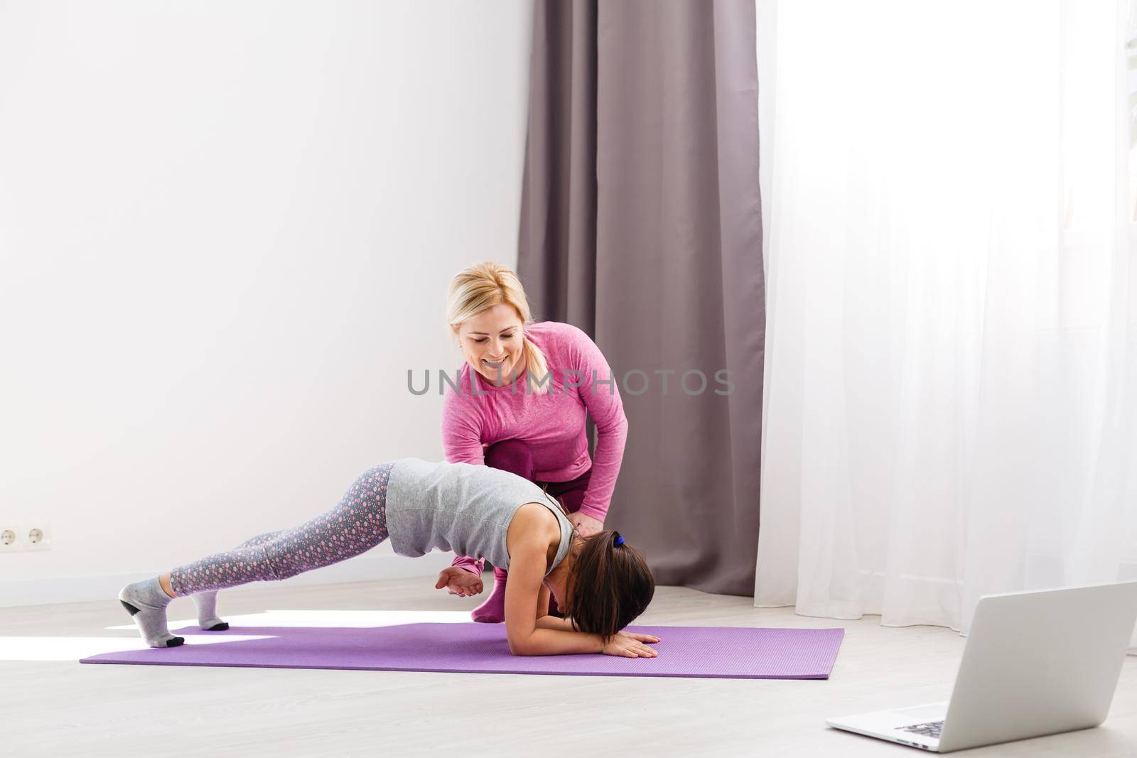 The girl does gymnastics at home. Gymnastics video tutorial. Gymnastic exercises. The idea for a children's activity in quarantine