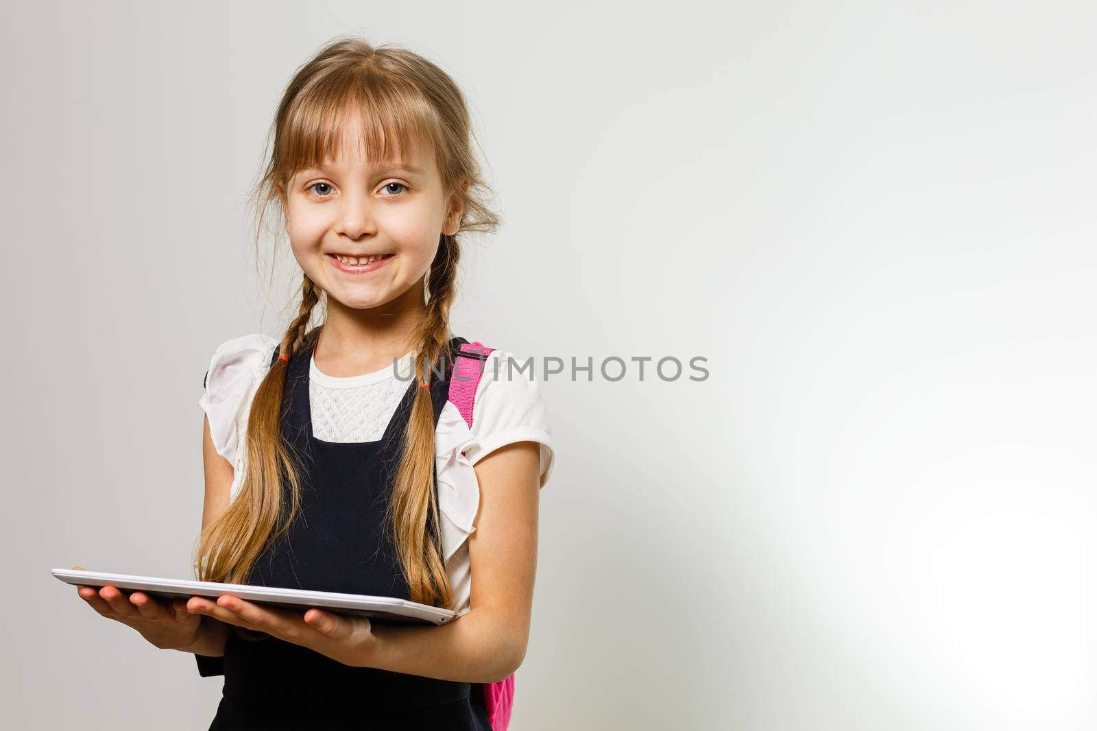 Little Funny girl in shirt. Isolated on white background. Baby girl in school. The child girl with textbooks. Girl studing. by Andelov13