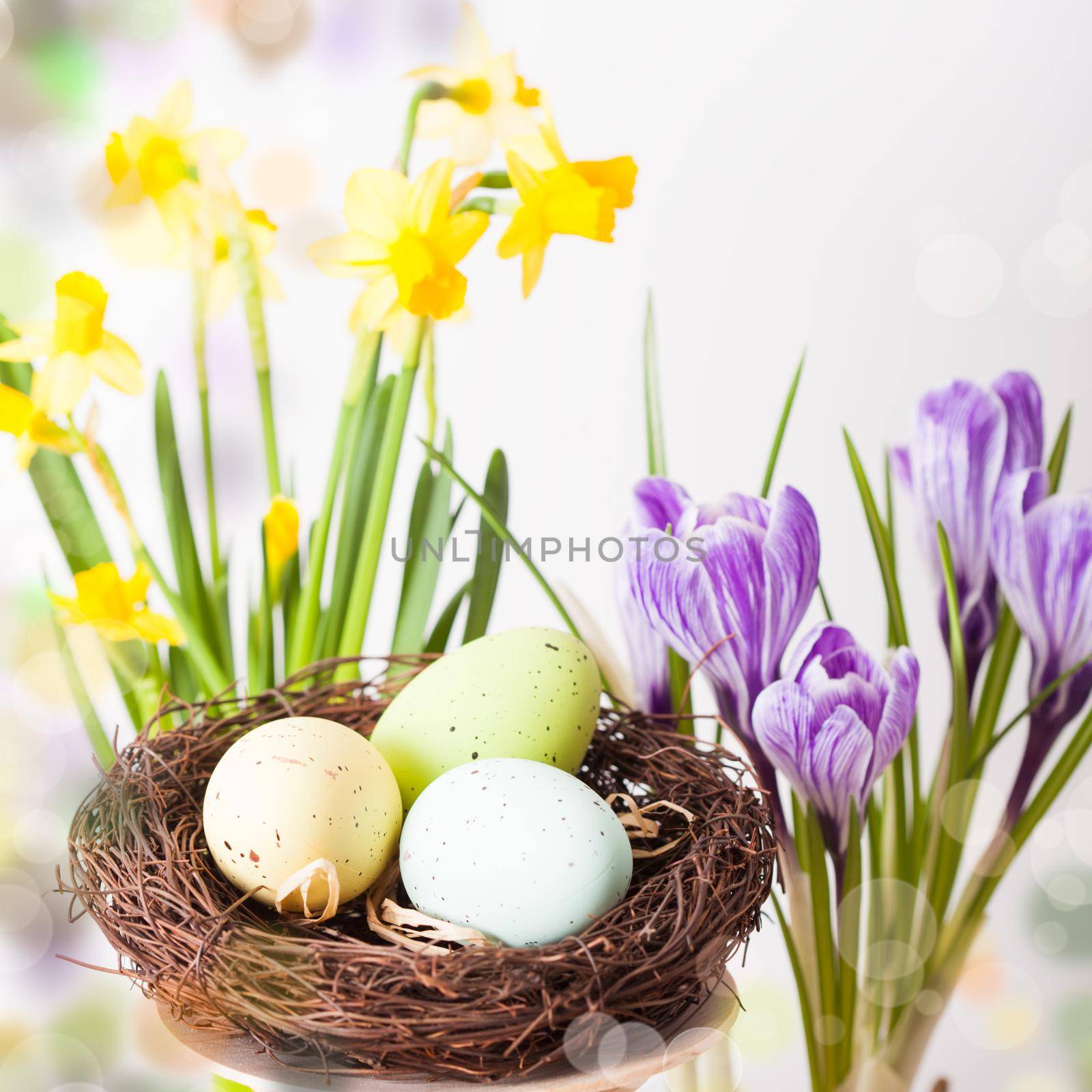 Easter decorations - egg in the nest and flowers on the table