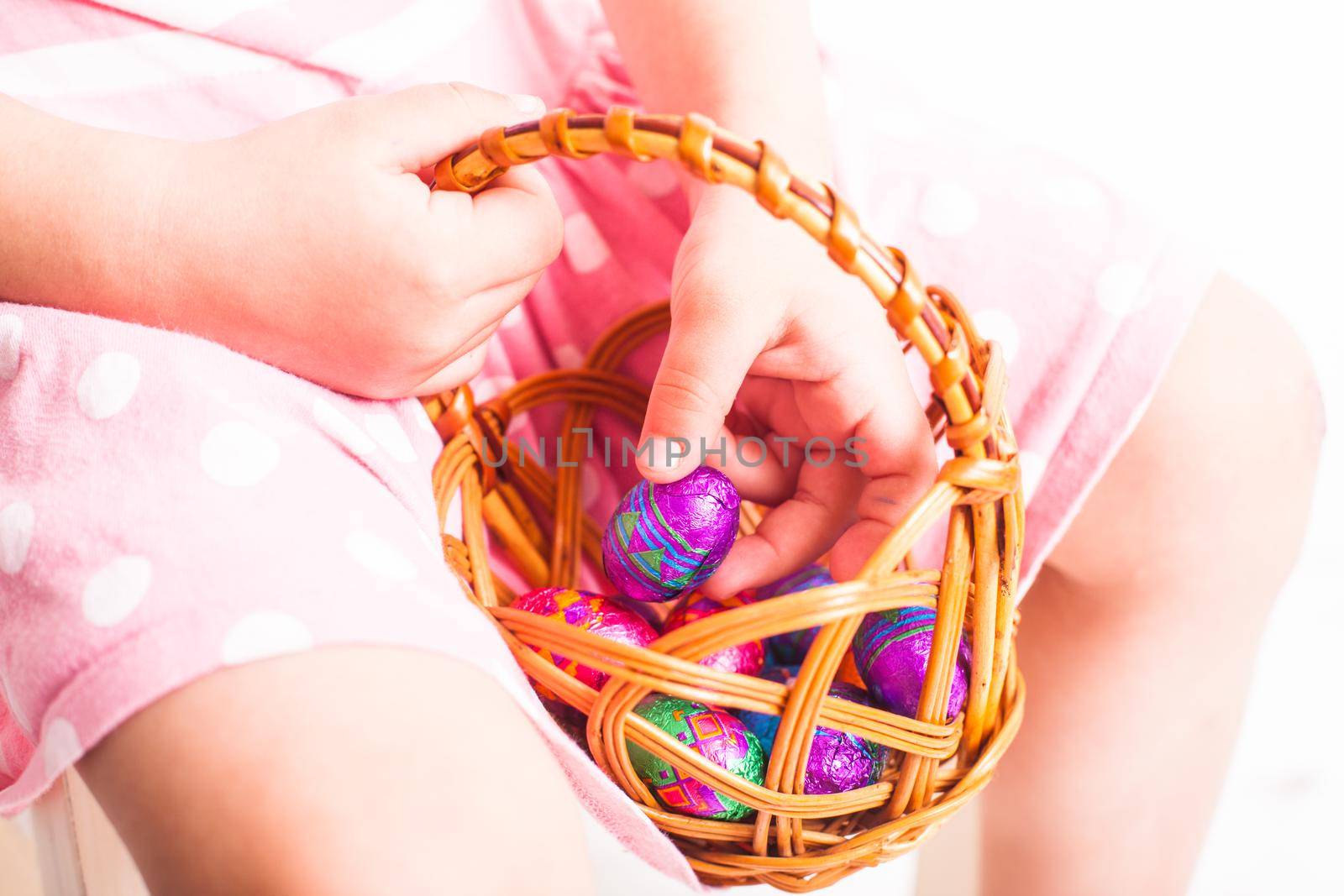 Girl eats a chocolate little eggs after Easter hanting