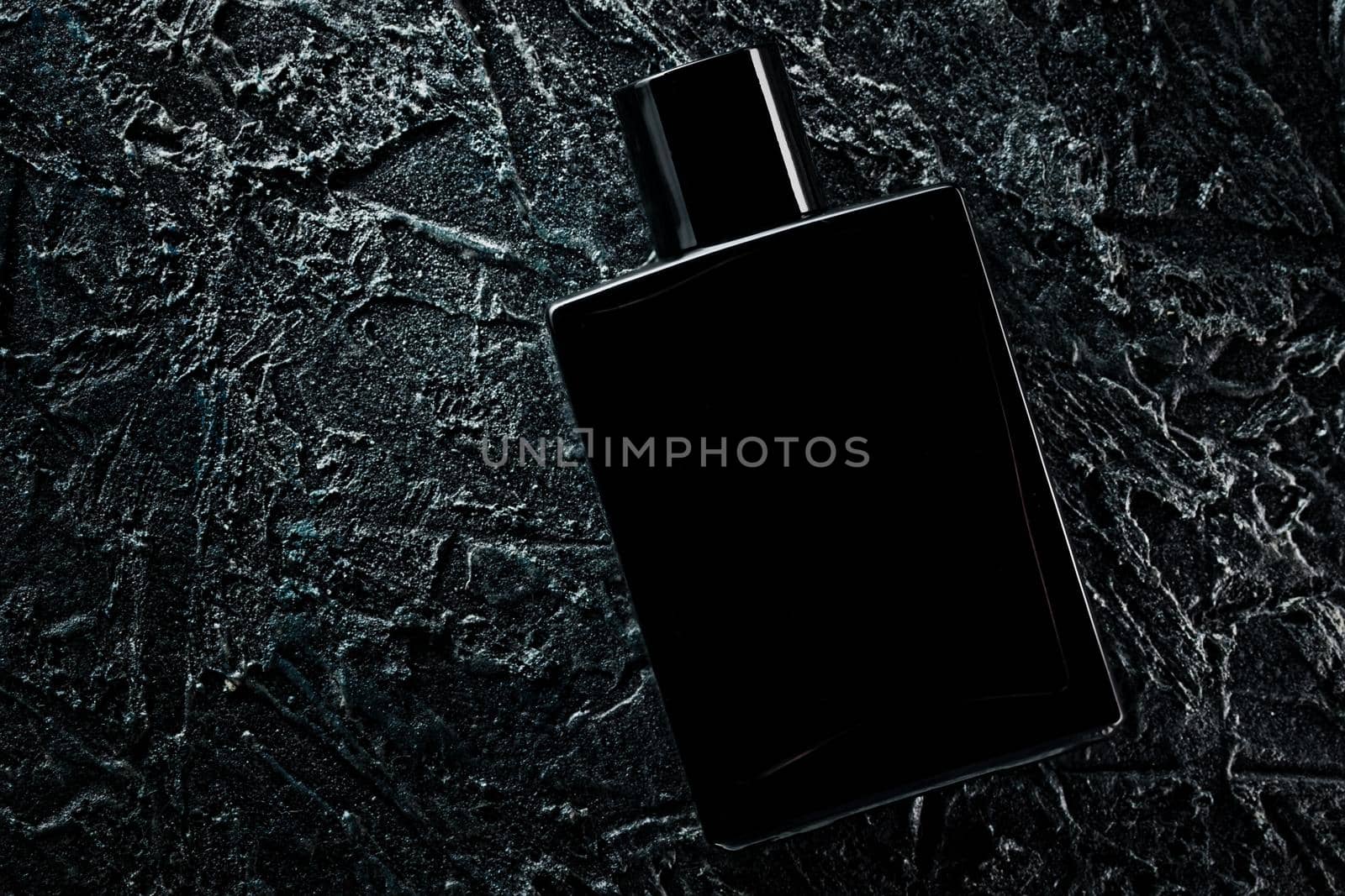 Men's fragrance of perfume or eau de toilette. Promotional photo of a black bottle on a dark background. Layout for copying text.