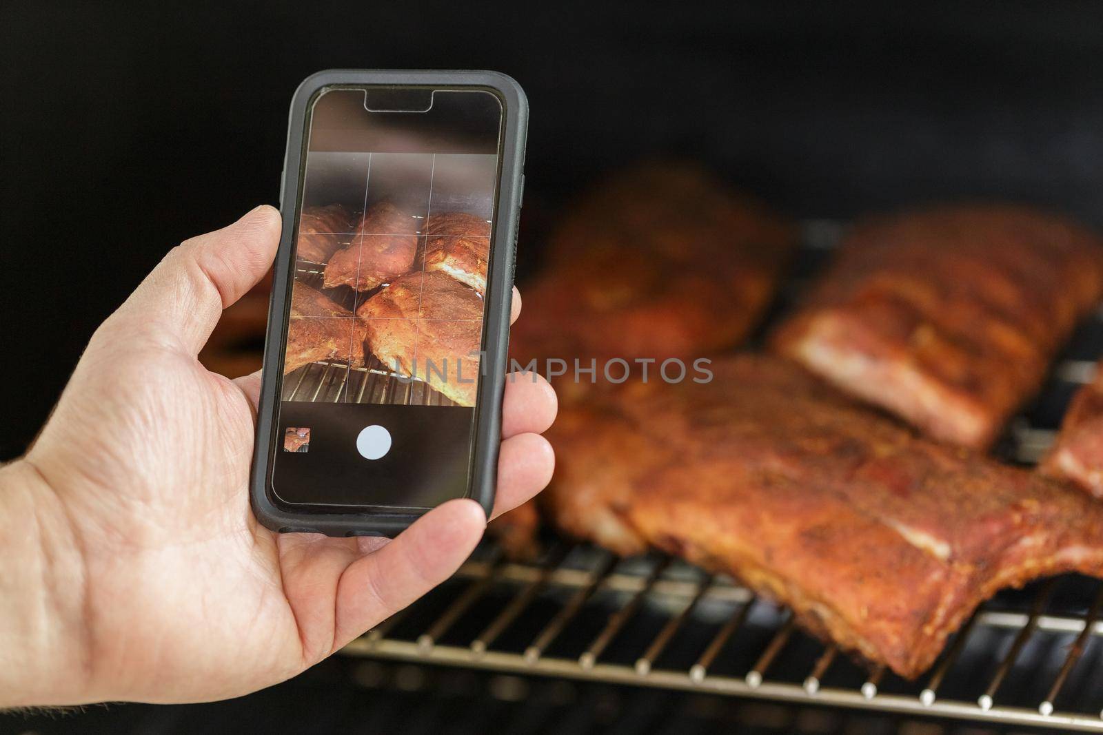Taking photo of the Beef Ribs being cooked on Barbecue Grill. Backyard BBQ party concept
