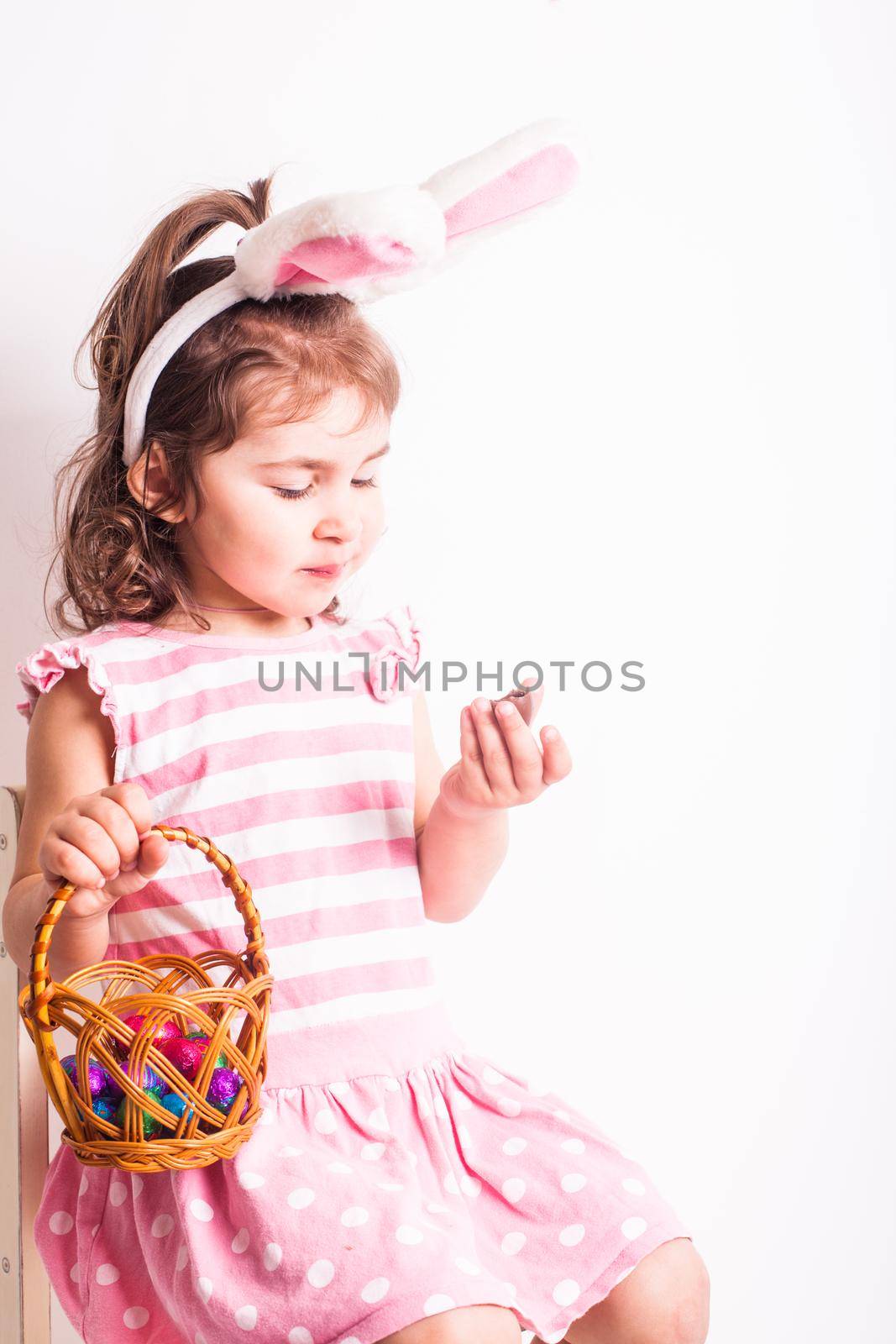 Girl eats a chocolate little eggs after Easter hunting