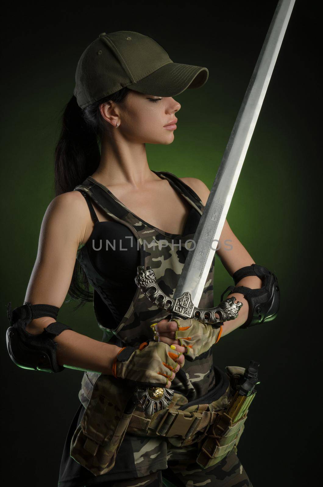 girl in military overalls airsoft posing with a gun in his hands on a dark background in the haze