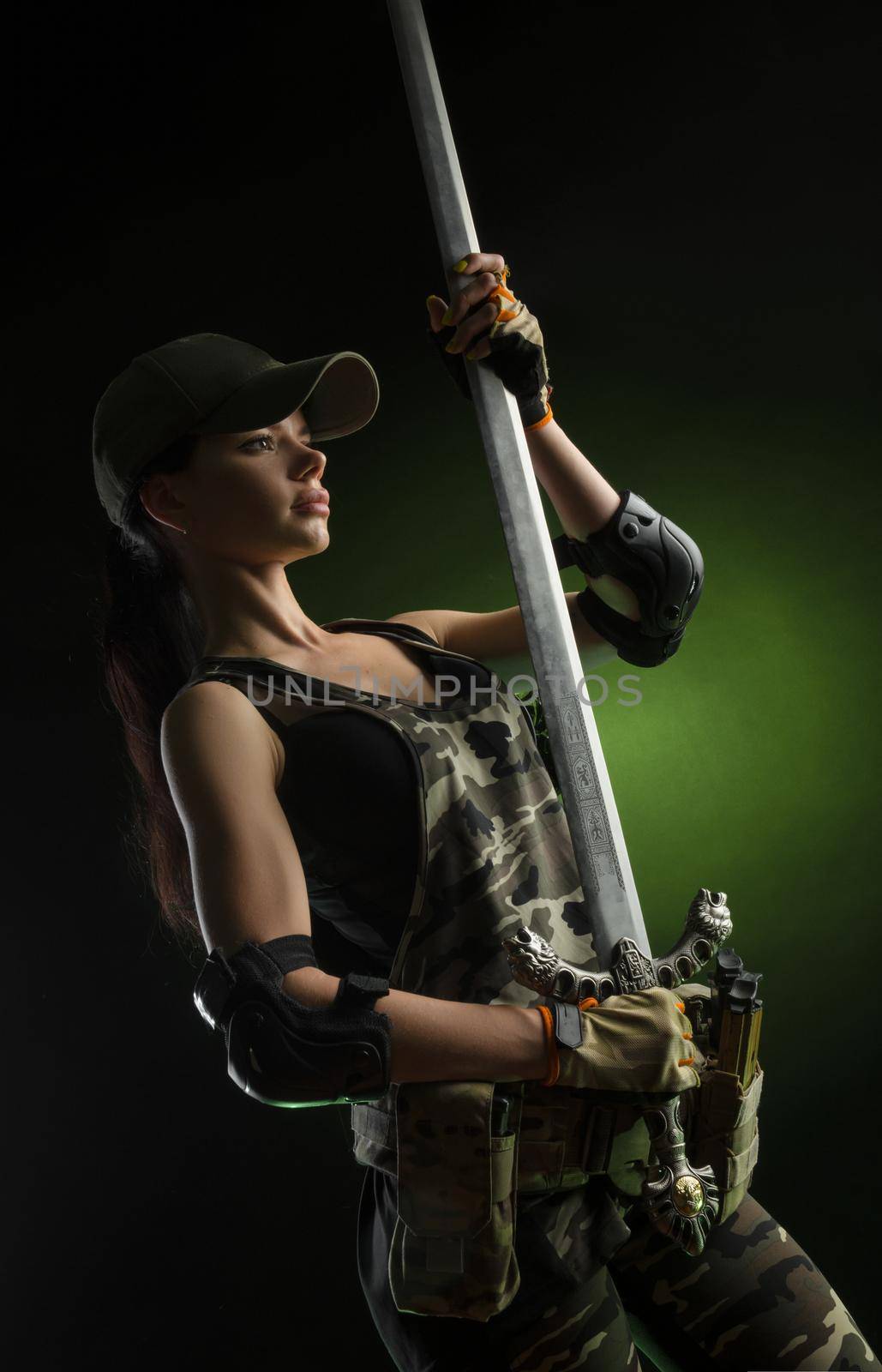 the girl in military special clothes posing with a gun in his hands on a dark background in the haze by Rotozey