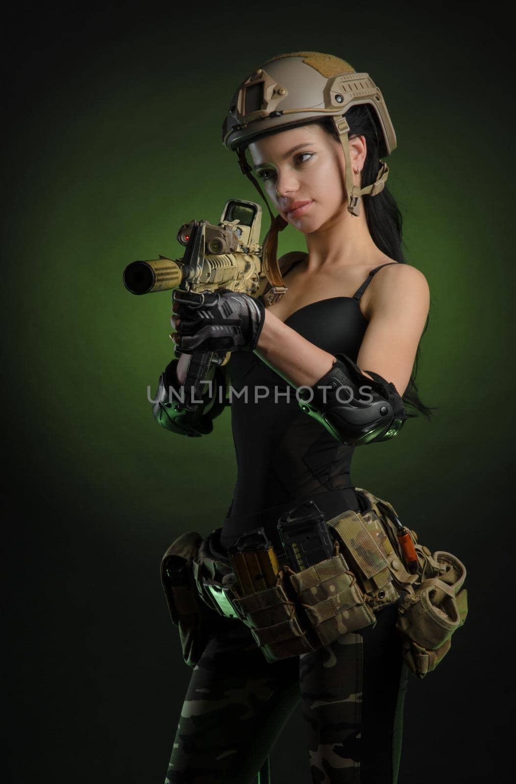 the girl in military special clothes posing with a gun in his hands on a dark background in the haze by Rotozey