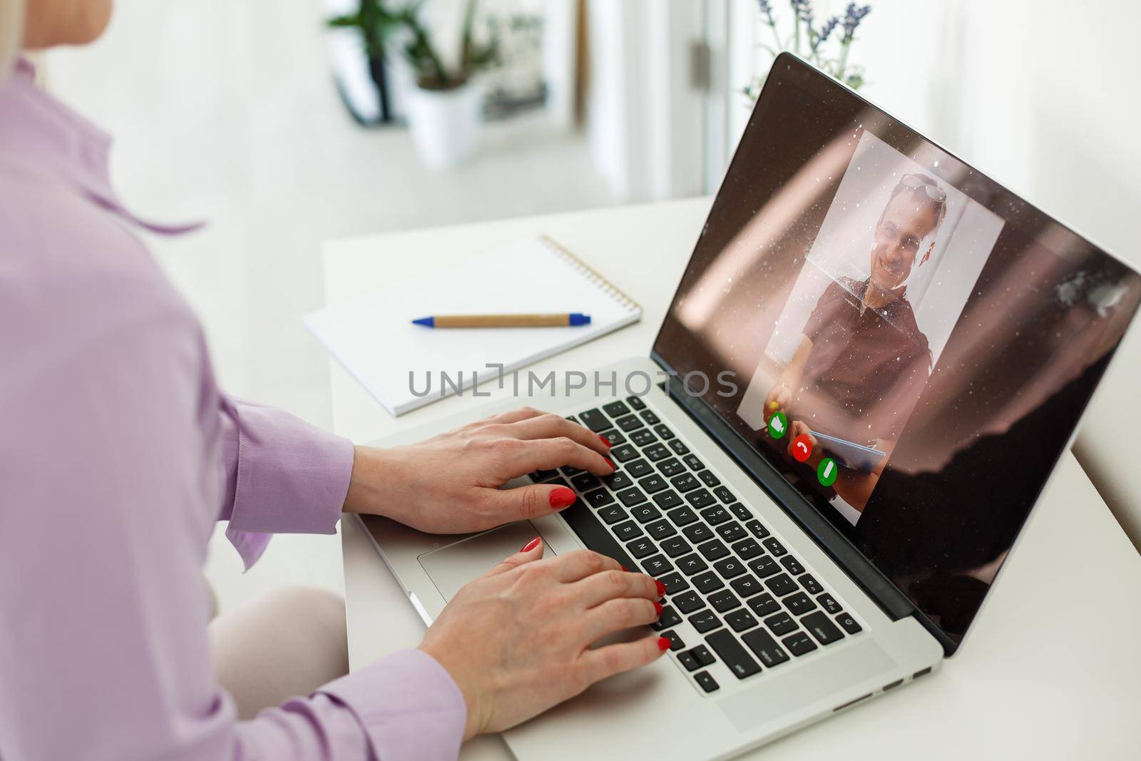 Cropped image of young female student attending online lecture on laptop at desk by Andelov13