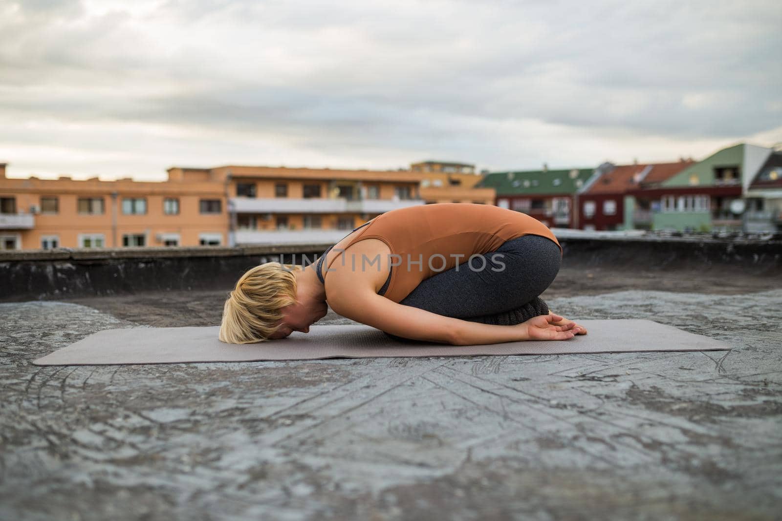 Woman practicing yoga on the roof by Bazdar