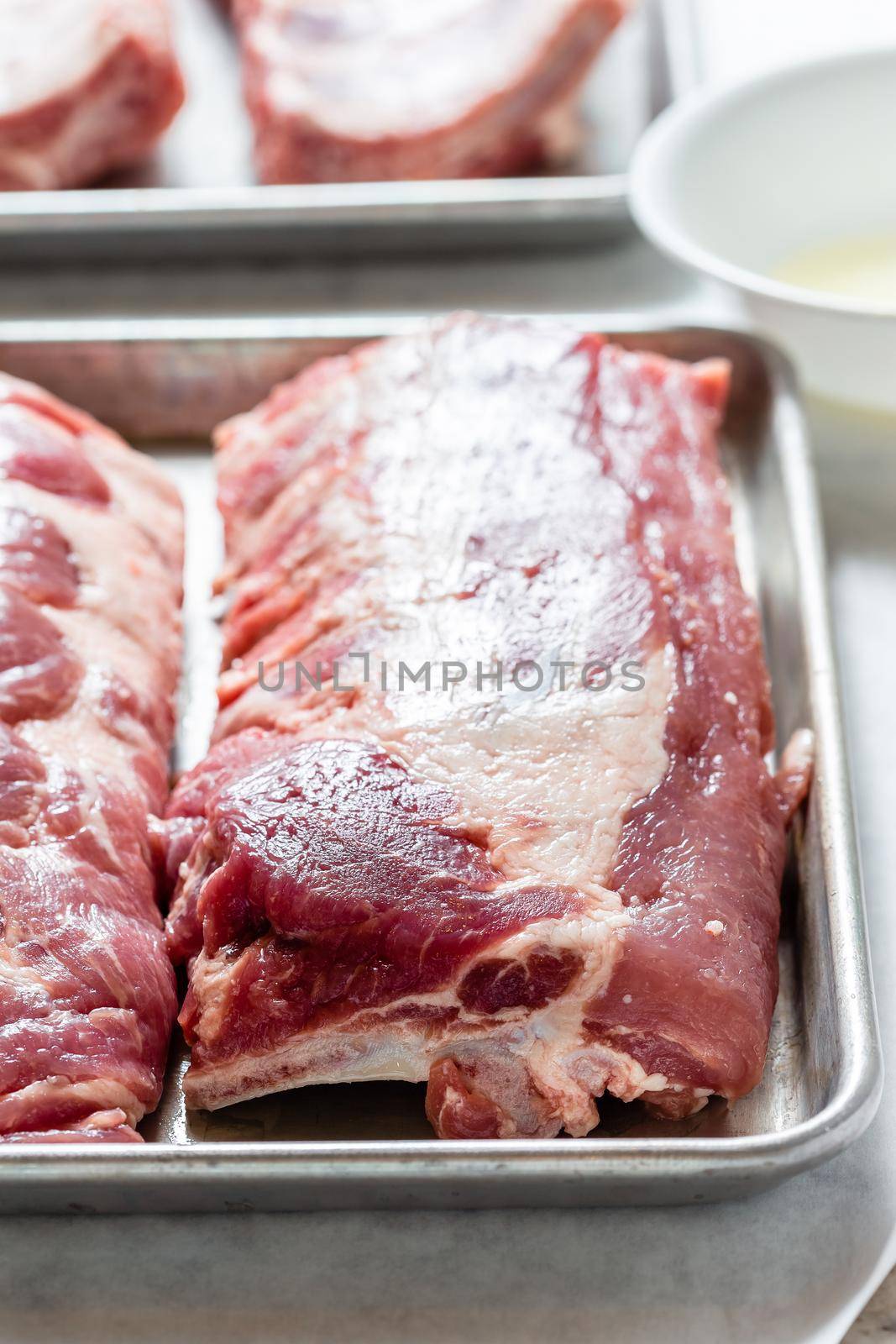 Spare ribs uncooked on stainless steel platter. Preparing bbq ribs dinner