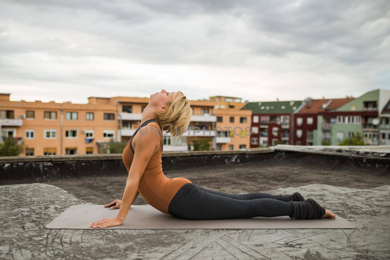 Woman enjoys  practicing yoga on the roof,Bhujangasana/Cobra Pose.