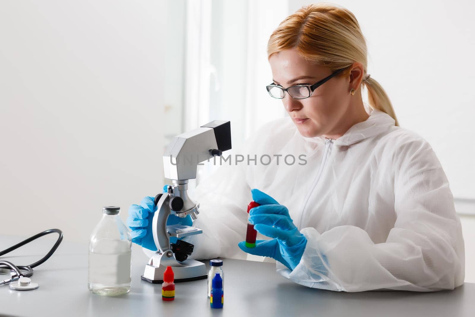 A beautiful female medical or scientific researcher using her microscope in a laboratory.