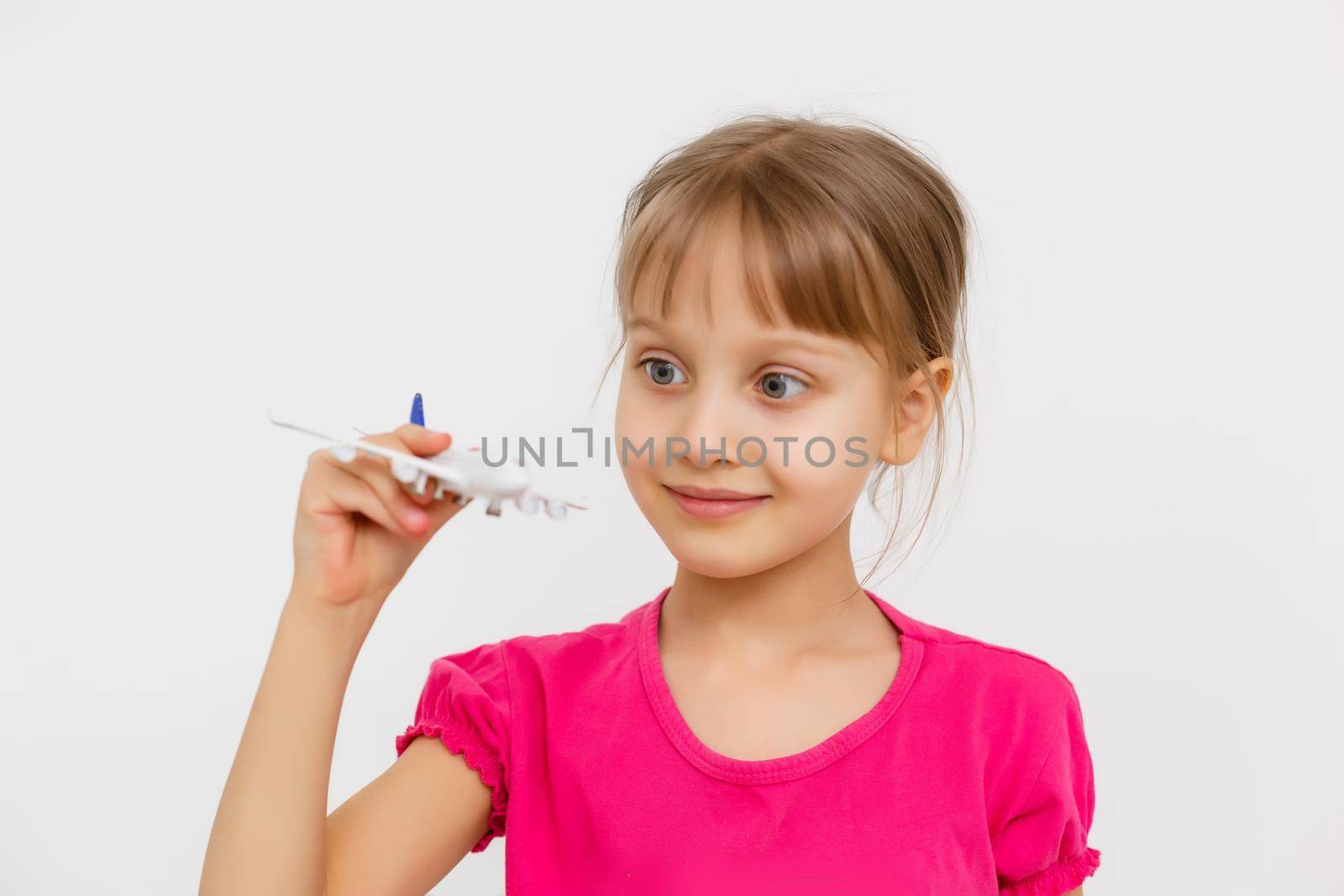 Little girl plays with a toy airplane