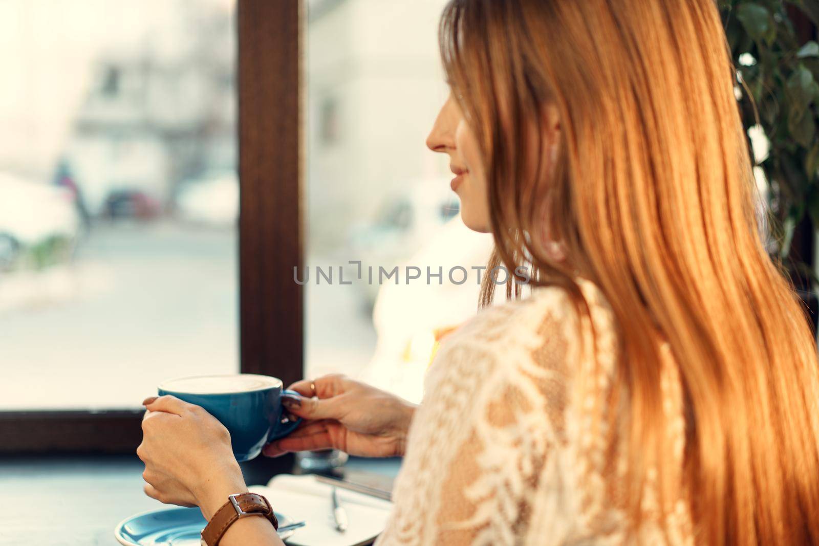 Nice young woman enjoying cup of coffee in a coffee shop. High quality photo
