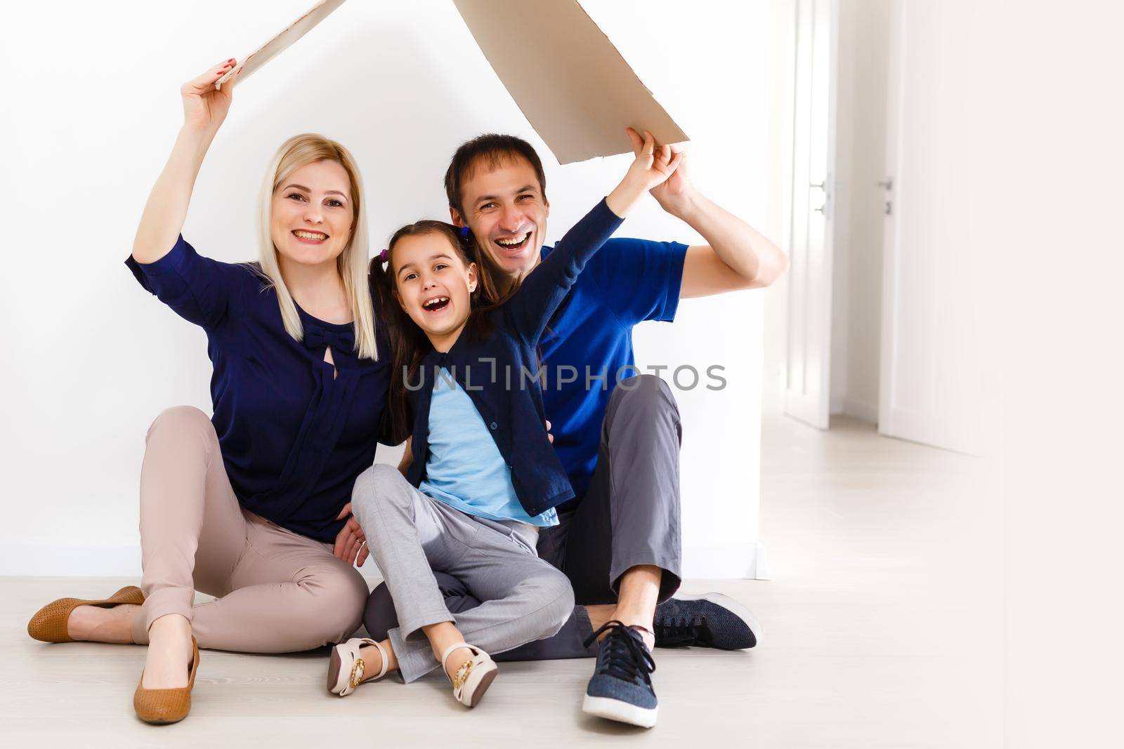 Portrait of happy family of three looking at camera with smiles