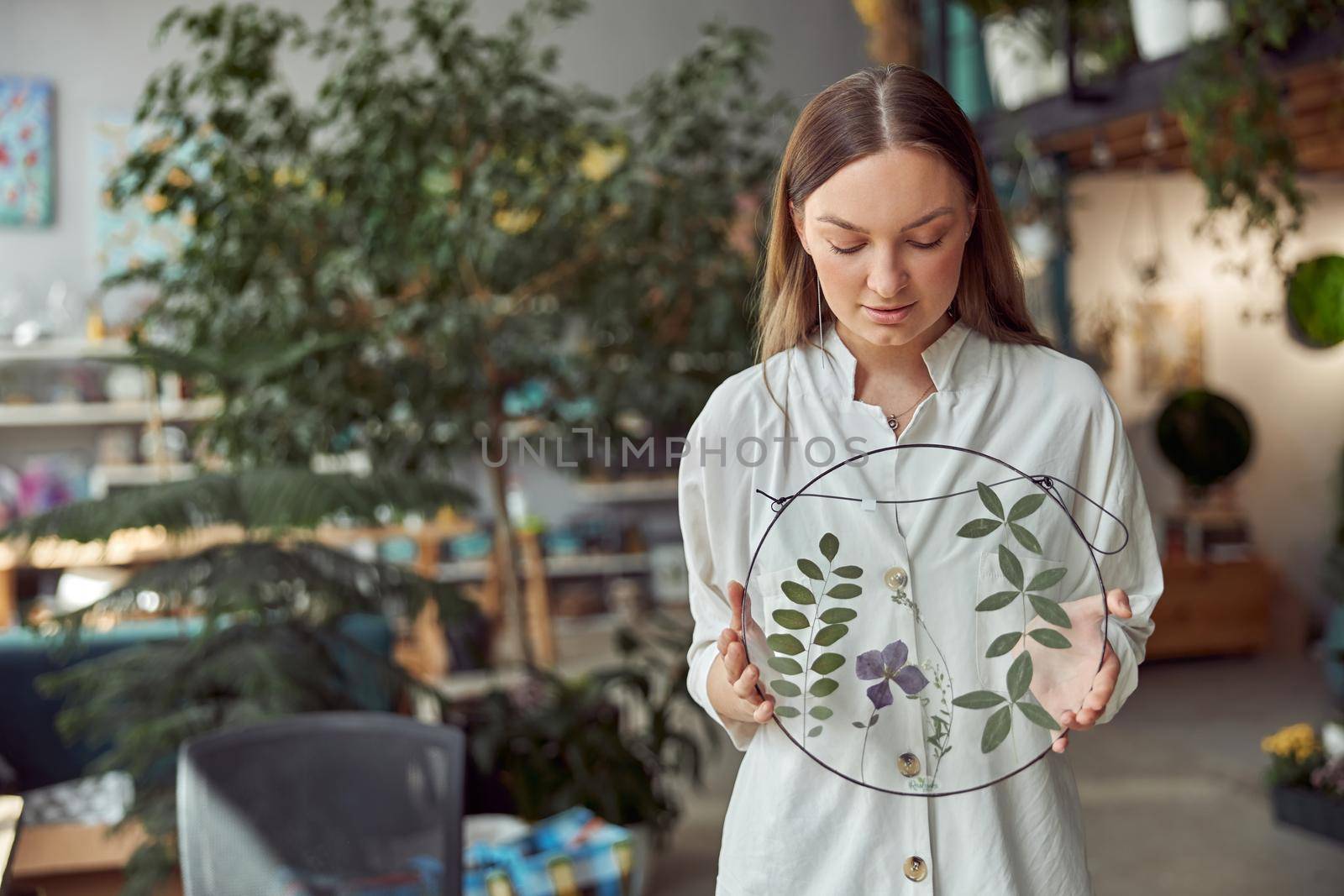 Young female caucasian woman florist is holding her work