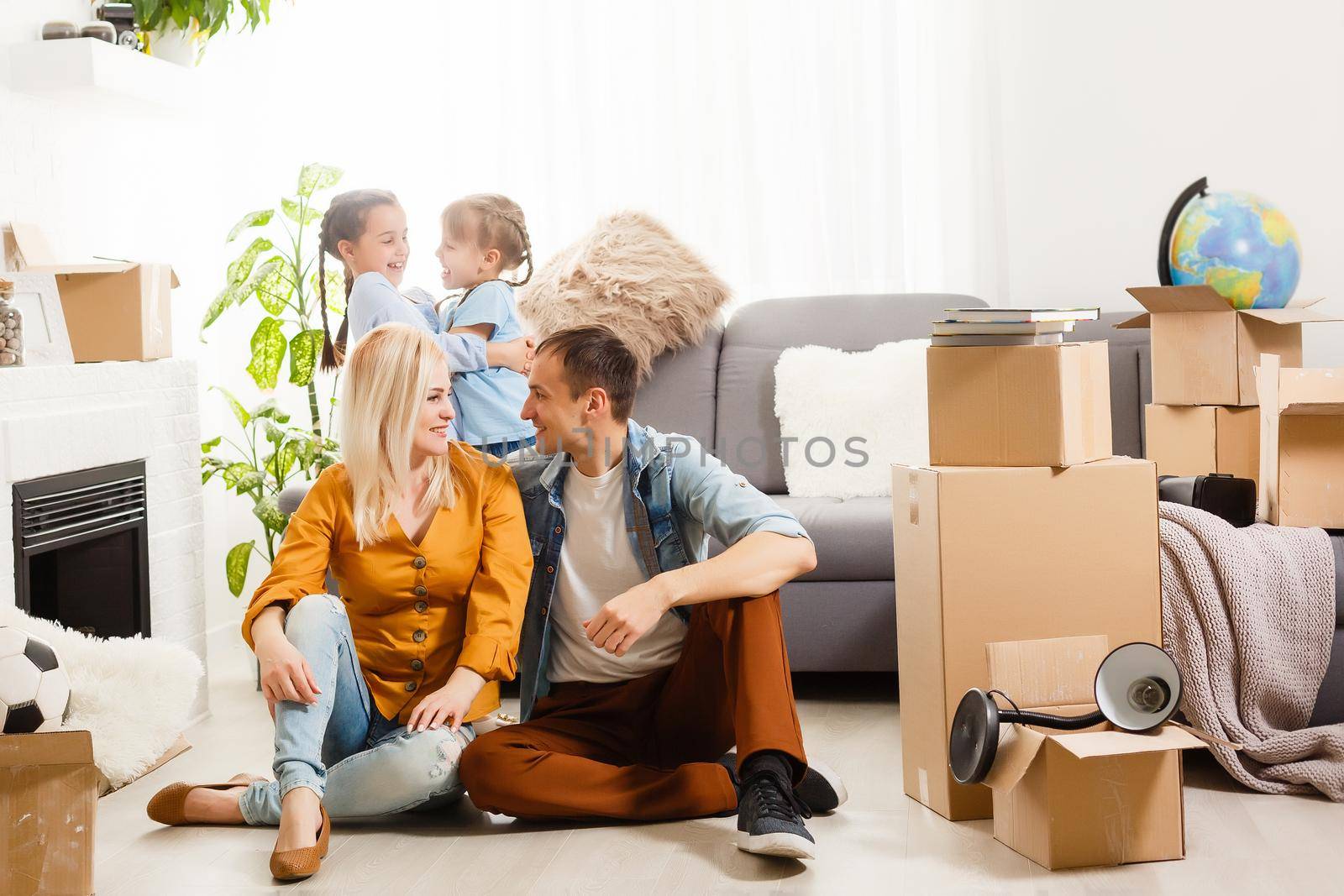 Happy family with cardboard boxes in new house at moving day.