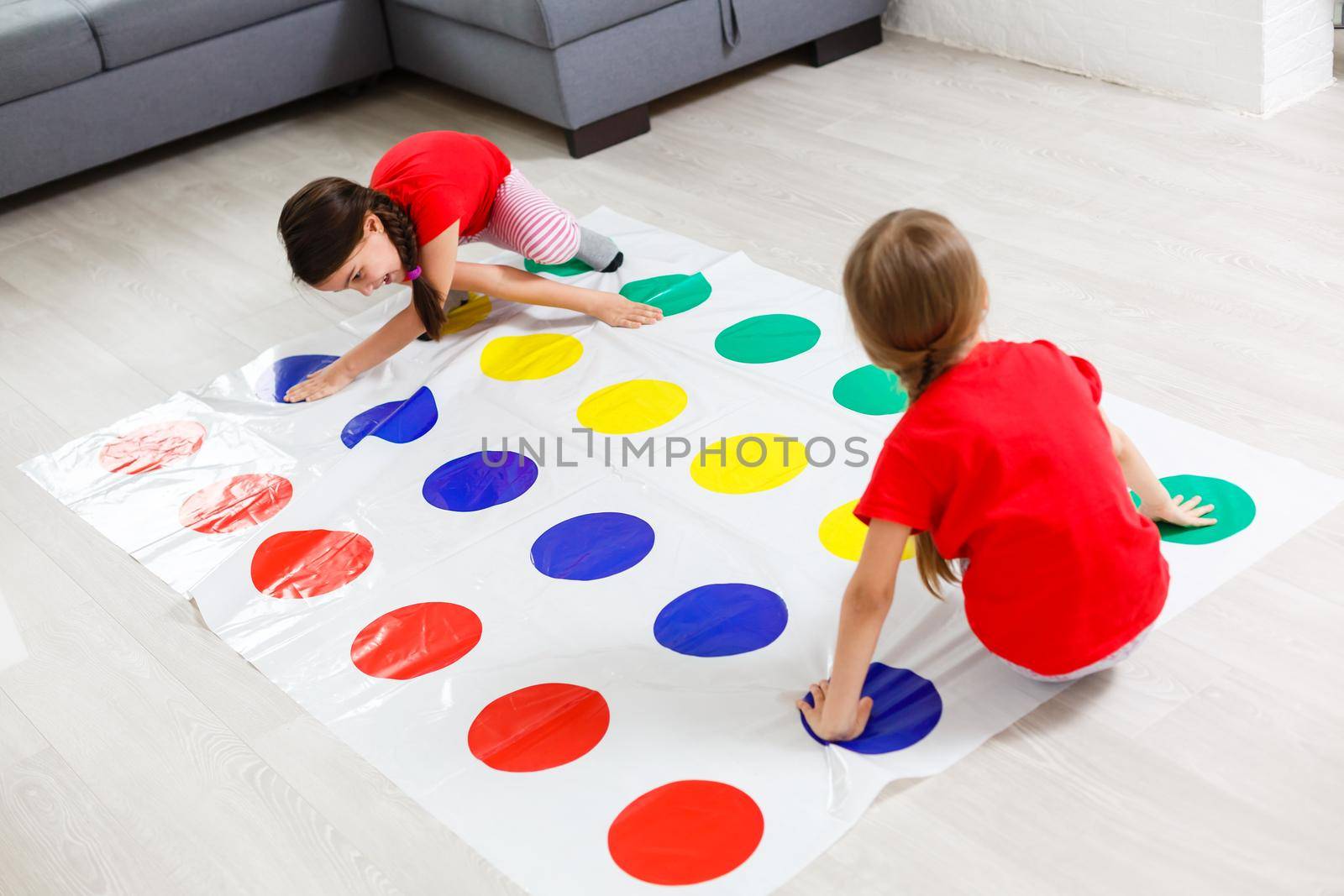 two little girls Having Fun Playing Game On Floor At Home. Siblings Friendship