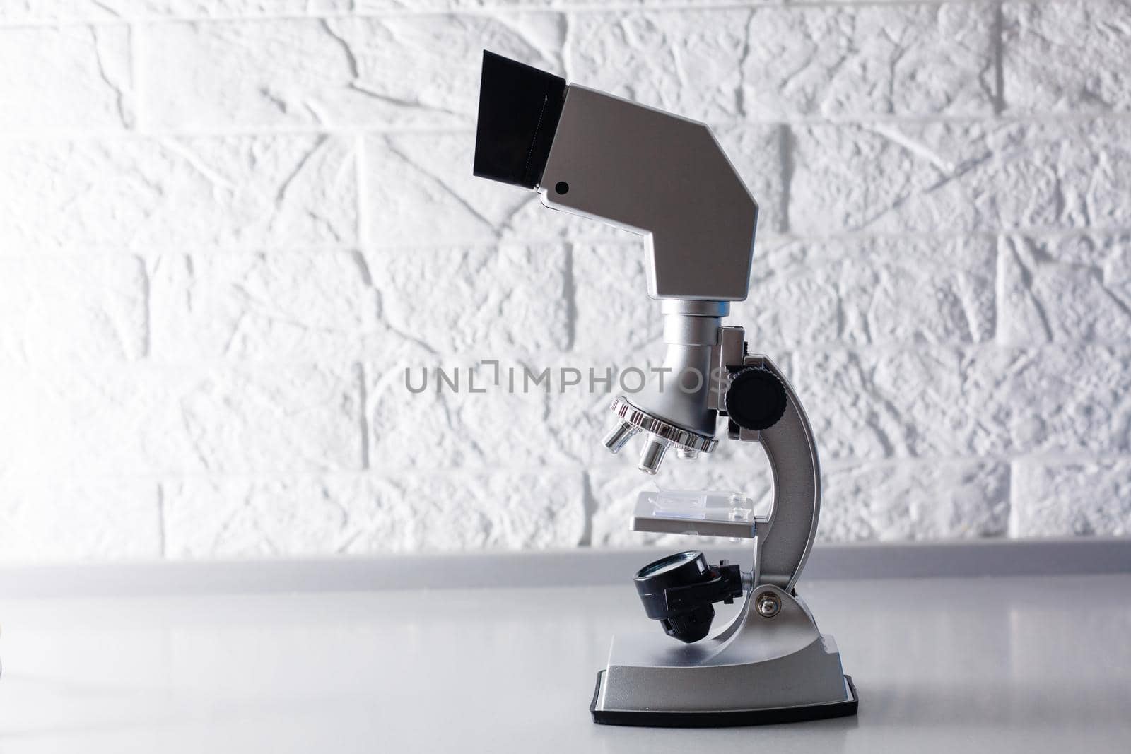 microscope stands on a table on a white background