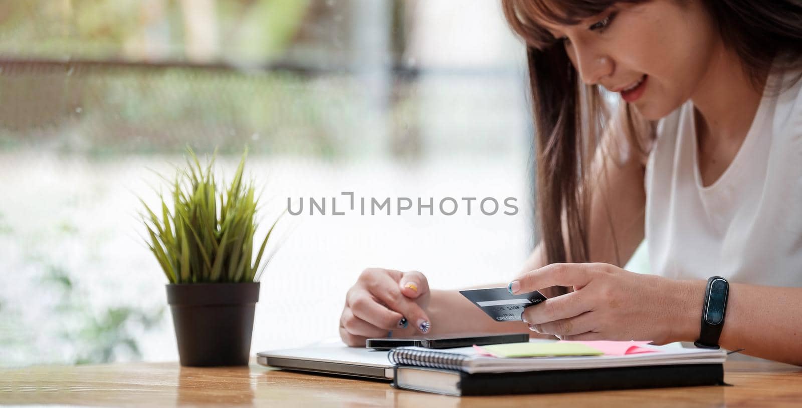 Woman use mobile phone for shopping online with credit card by wichayada