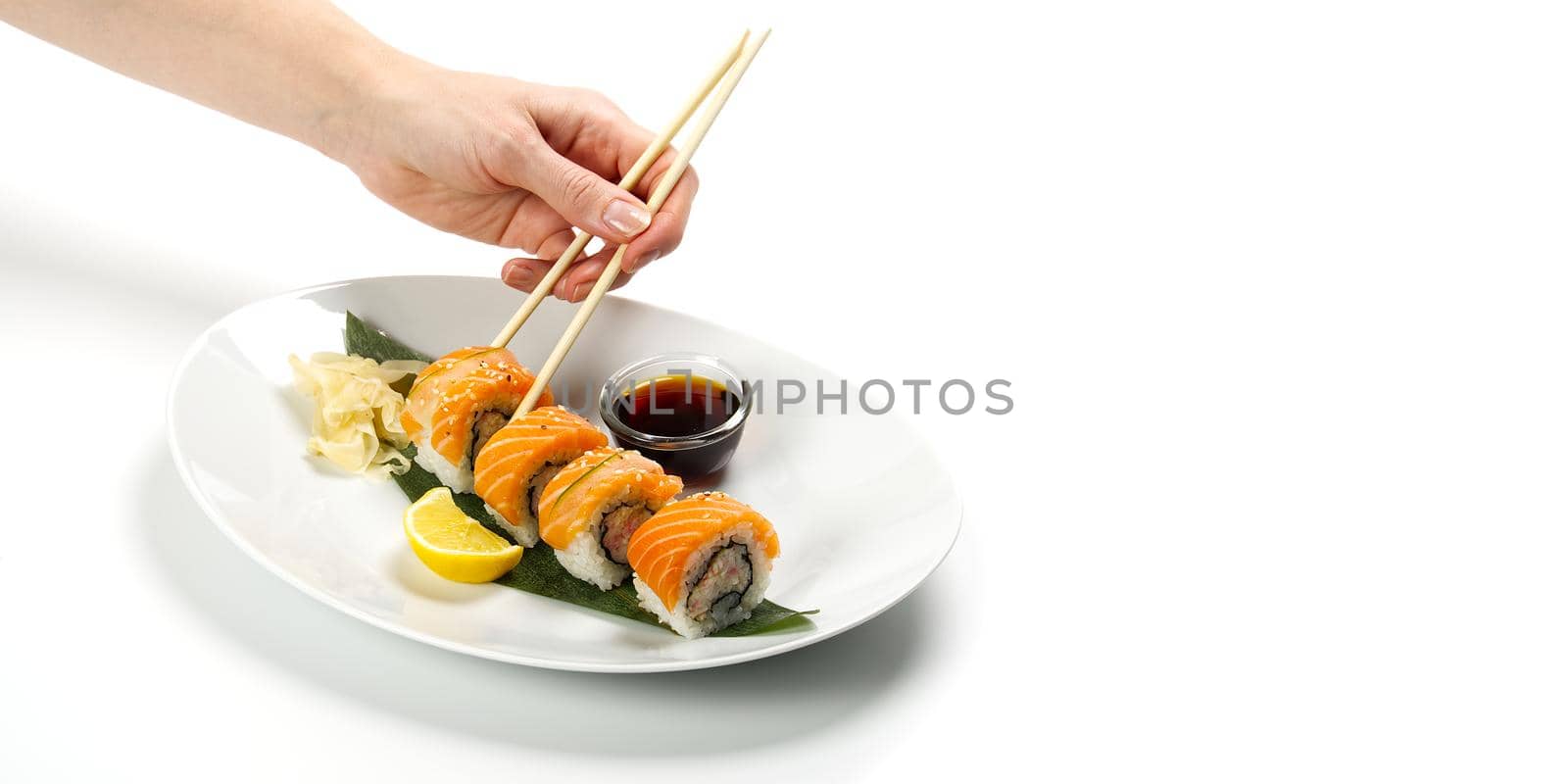 Sushi and soy sauce in a white bowl and wooden chopsticks white table. Japanese food. Japanese seafood Sushi Set. Sushi bar Menu. by PhotoTime