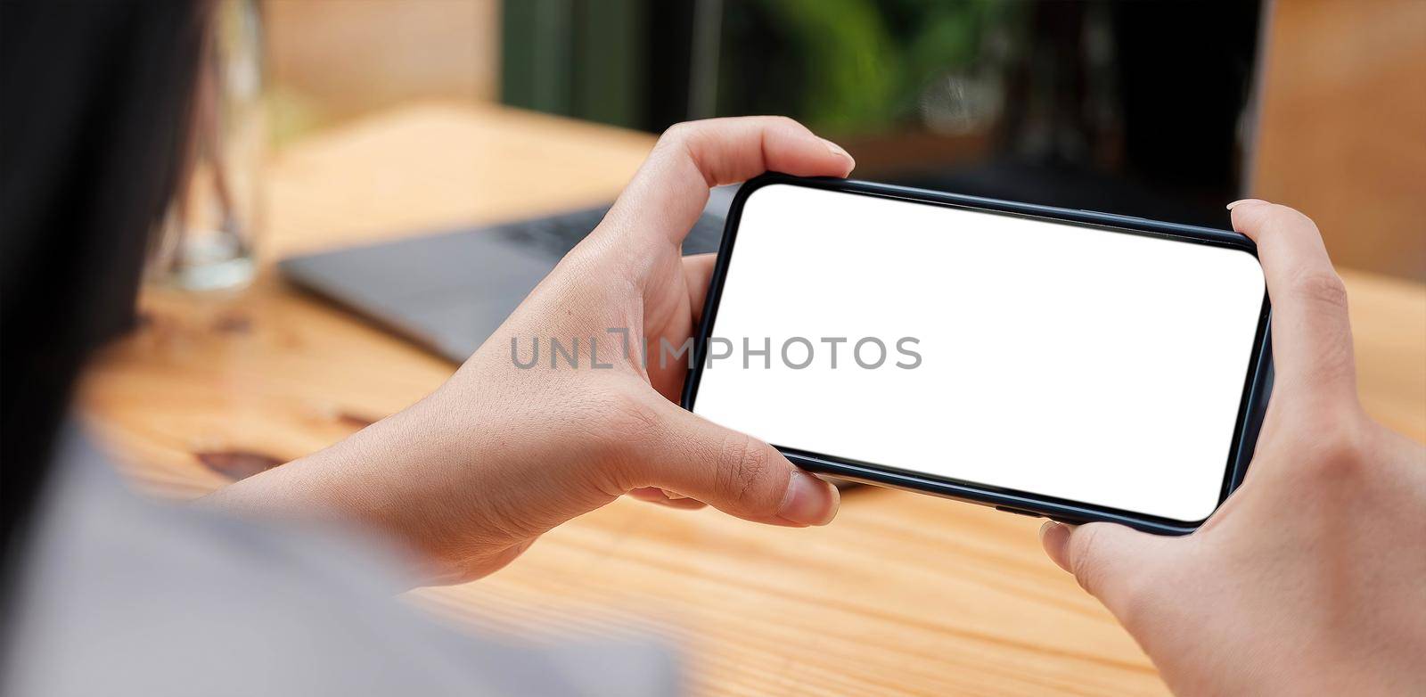 Mockup image woman hand holding texting using black mobile,cell phone with copy space,white blank screen for text.concept for contact business,people communication,technology electronic device by wichayada