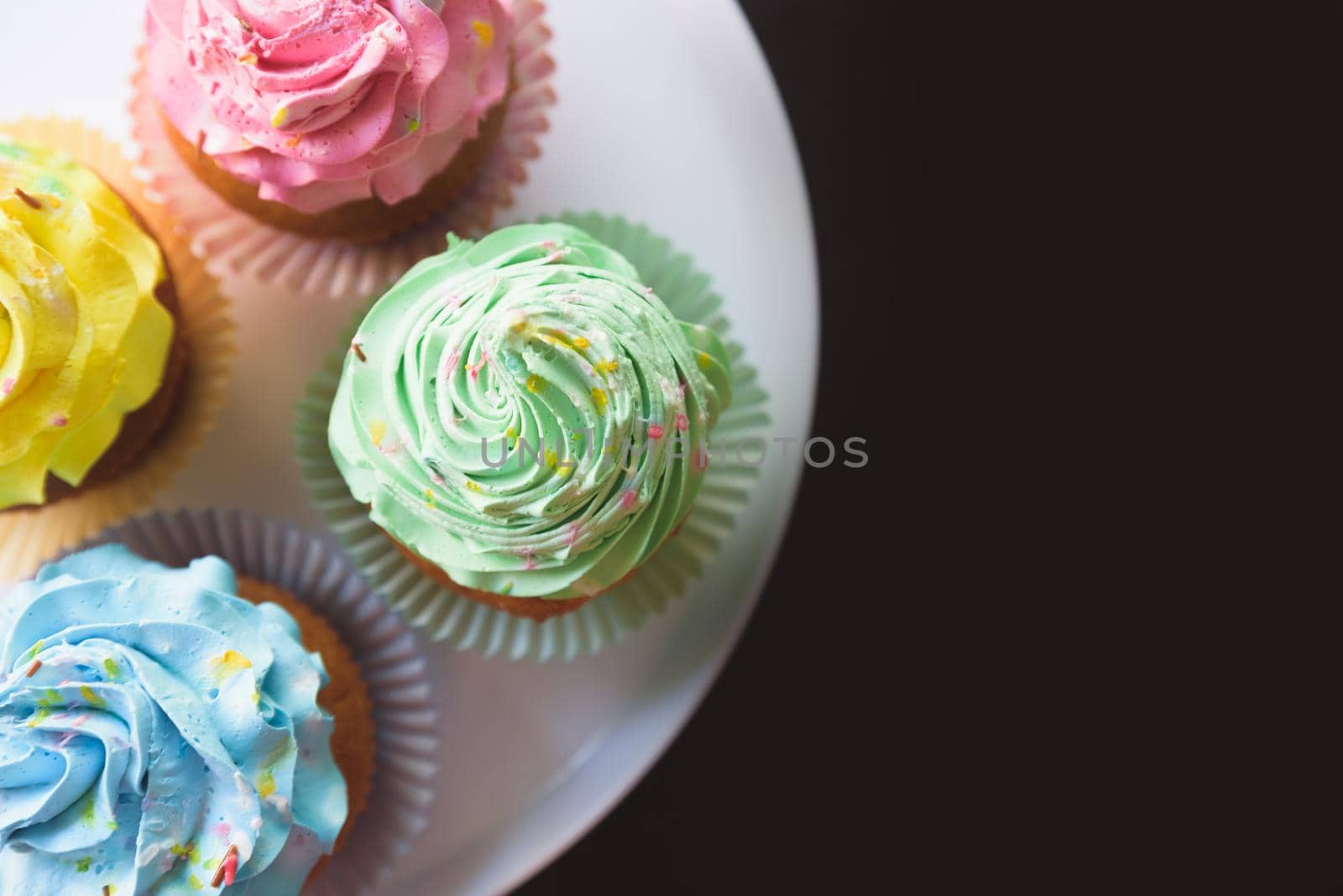 colorful cupcakes on black background.