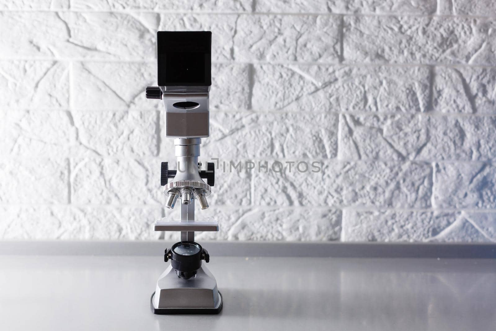 microscope stands on a table on a white background