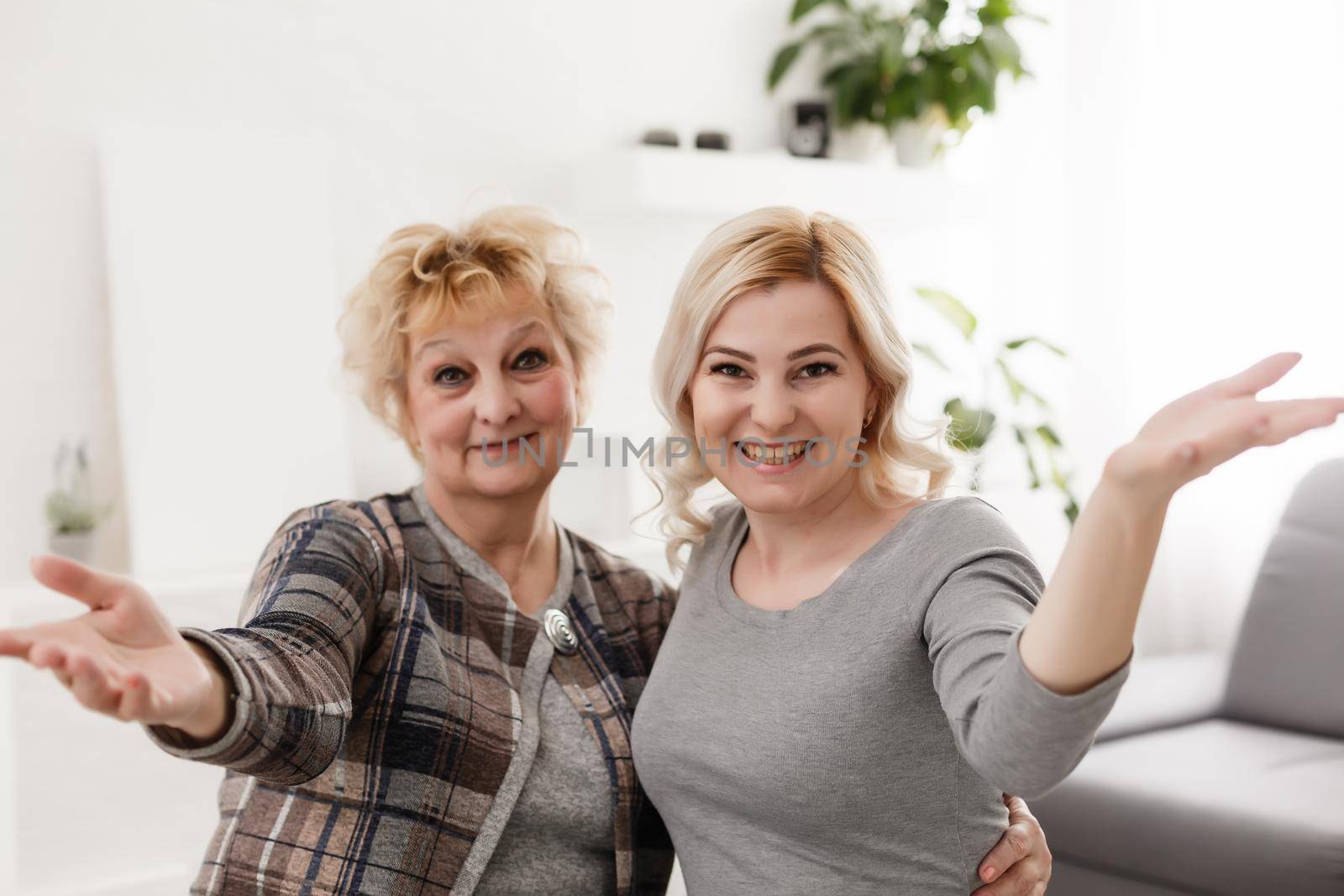 Self portrait of charming pretty stylish positive cheerful mom and adult child shooting selfie on front camera gesturing v-sign with two fingers isolated on grey background rest relax leisure concept