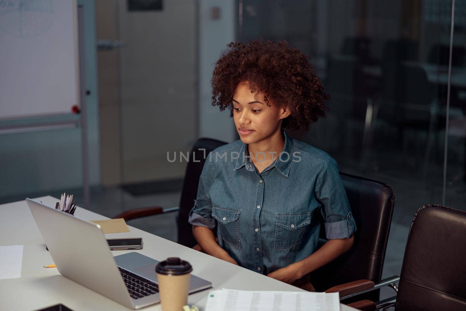 Smiling young businesswoman using laptop at her workplace by Yaroslav_astakhov