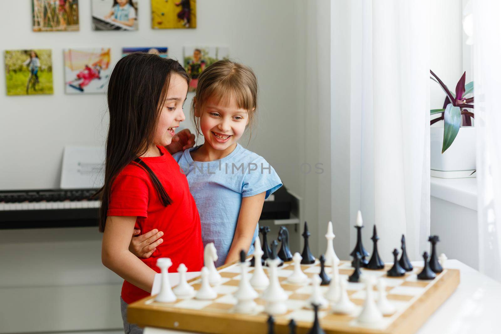 Two cute children playing chess at home