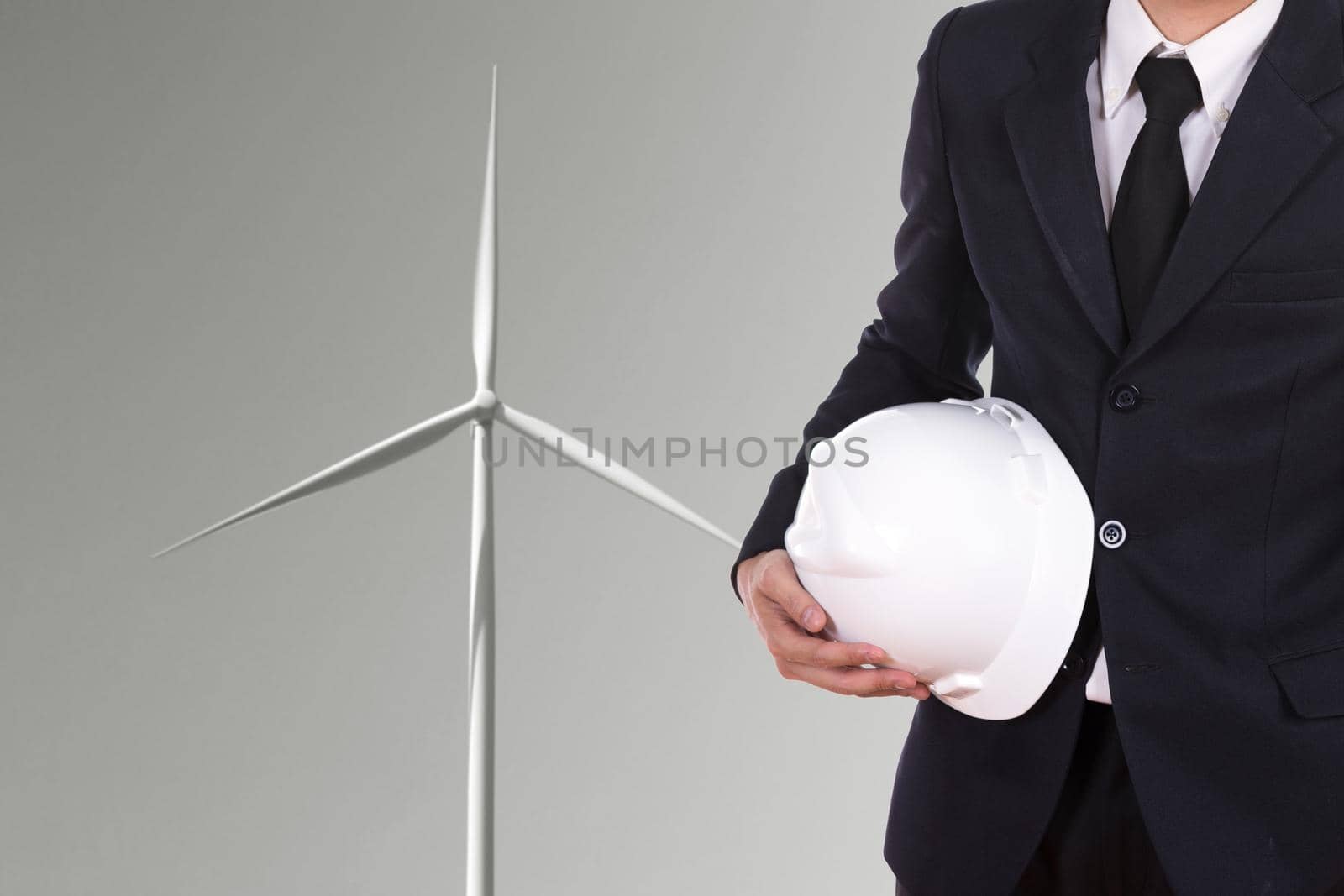 engineer holding helmet with wind turbine background by geargodz