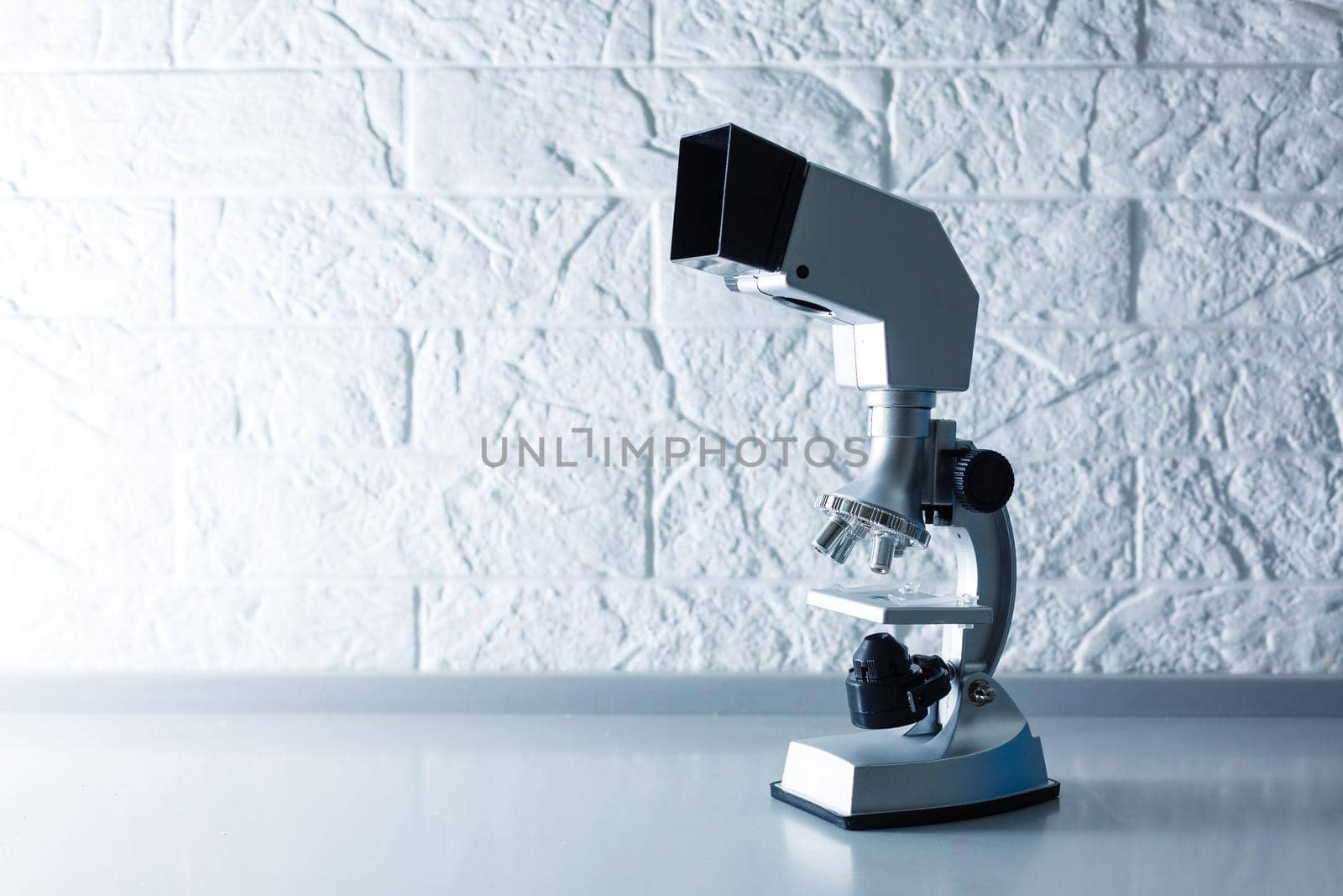 microscope stands on a table on a white background