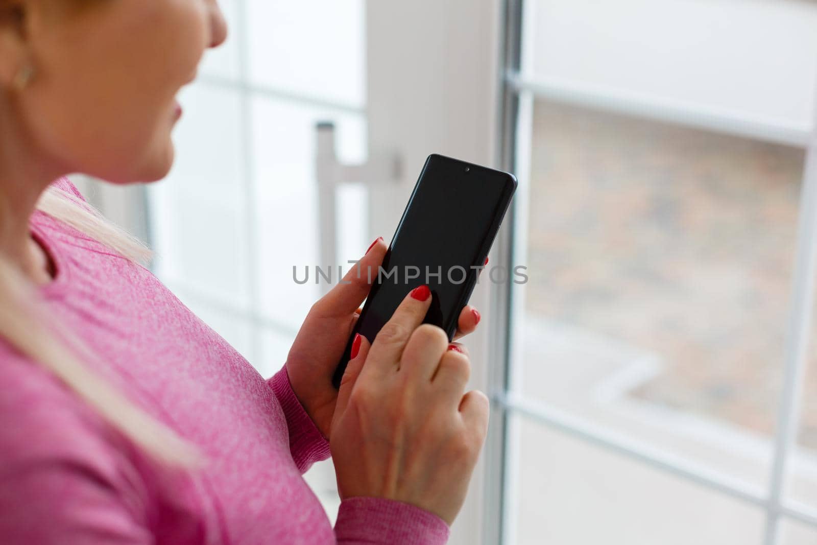 Portrait of beautiful young woman using her mobile phone at home.