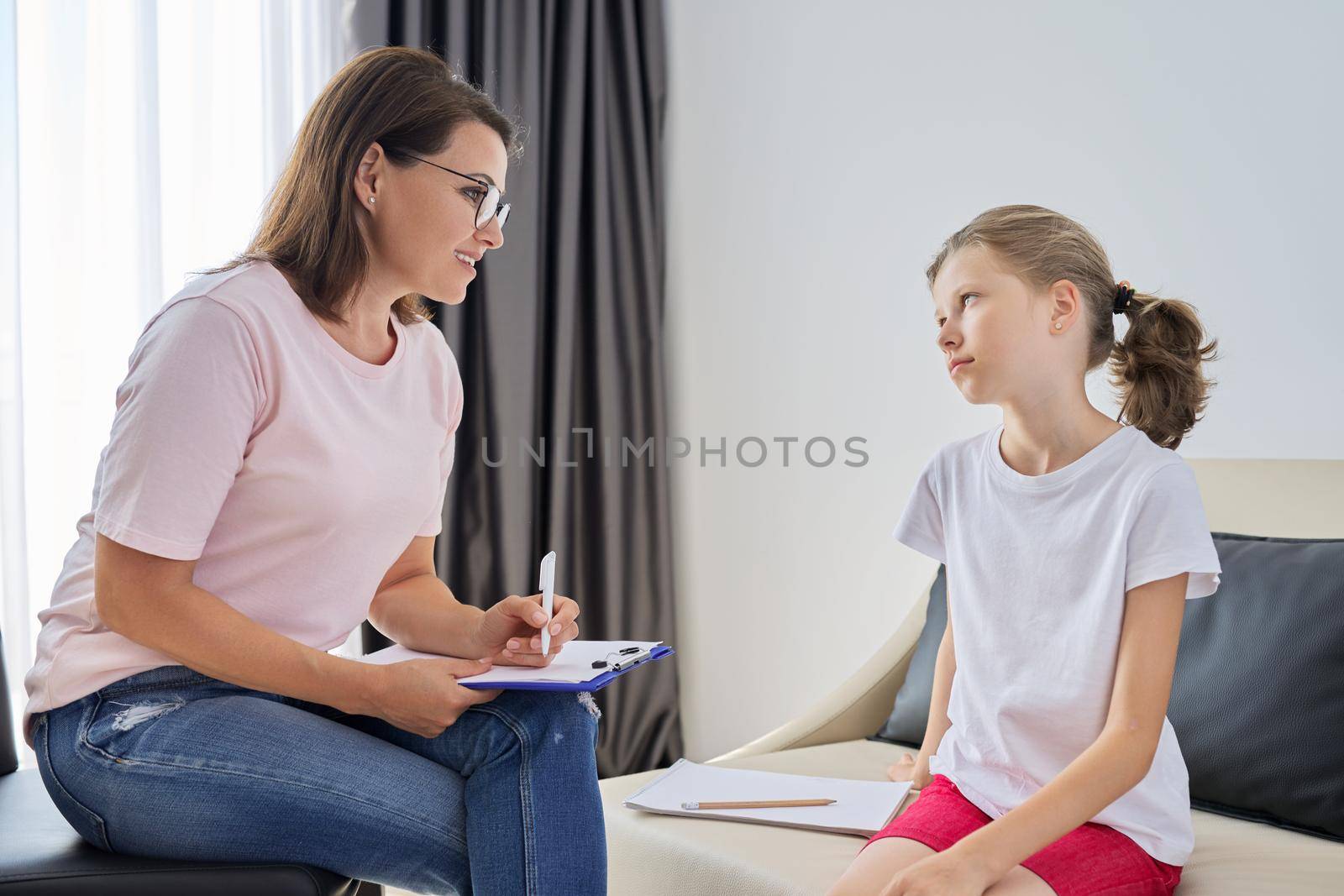Meeting of pre-teen child girl and female social worker psychologist teacher at office. Psychotherapy, psychology, alternative therapy, mental health of children and adolescents