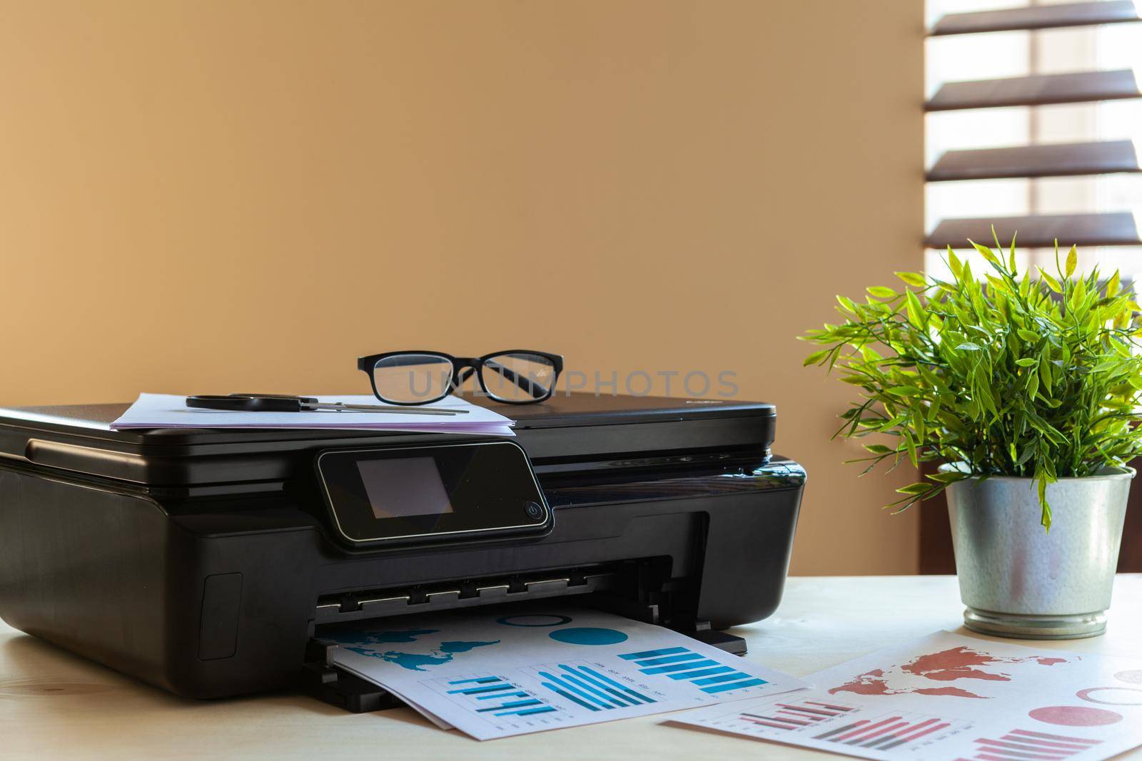 Front view of a black printer machine on a table. Close up.