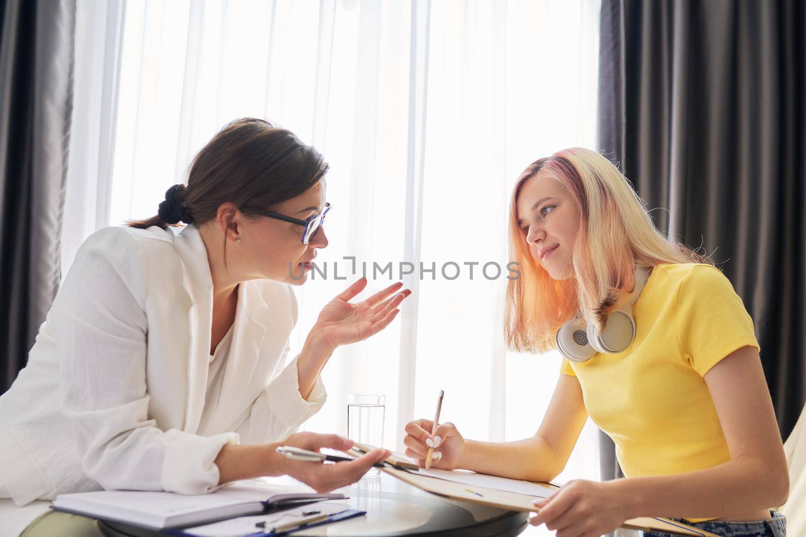 Woman social worker talking to teenage girl in office. Psychological assistance in adolescence. Mental health of adolescent children, problem, trauma, mental health concept