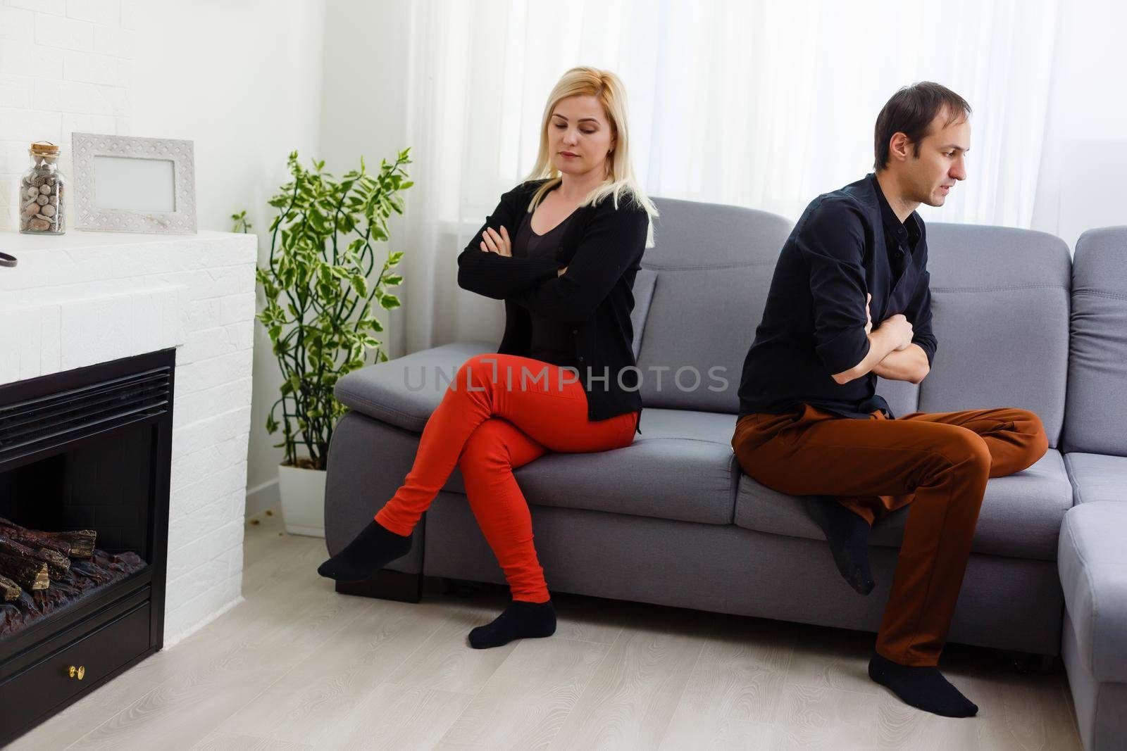 Happy young couple is hugging and smiling while sitting on the couch at the psychotherapist.