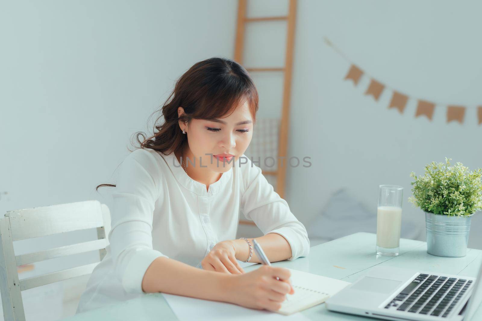 Asian young woman use laptop to work at home by makidotvn