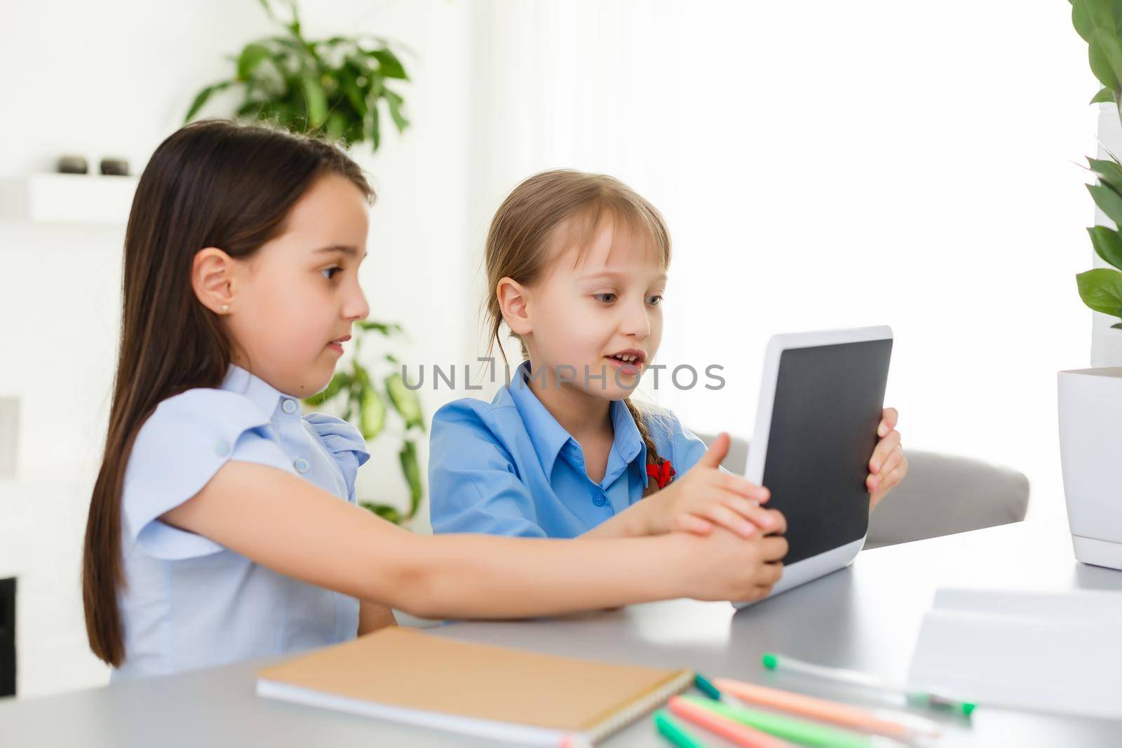 Pretty stylish schoolgirls studying during her online lesson at home, social distance during quarantine, self-isolation, online education concept