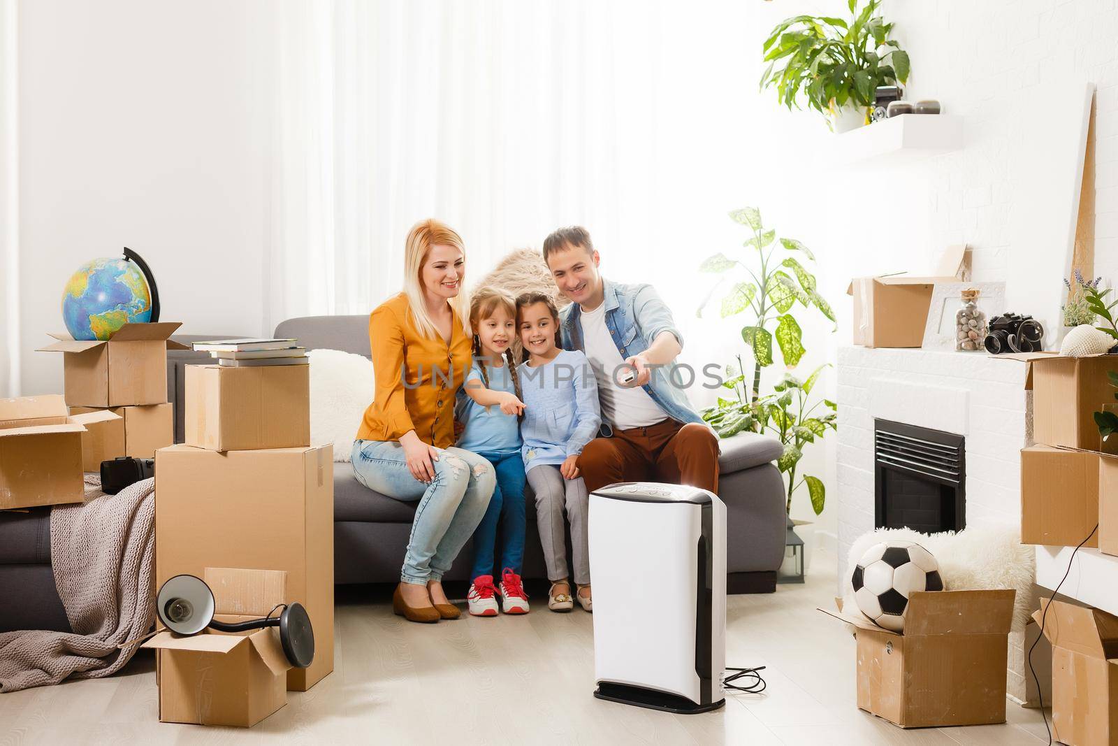 air purifier in living room with happy family moving to new apartment by Andelov13