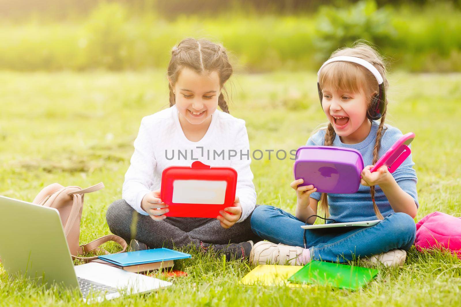 kids on the picnic in school grass yard are coming eat lunch in box. parent take care of childcare. by Andelov13