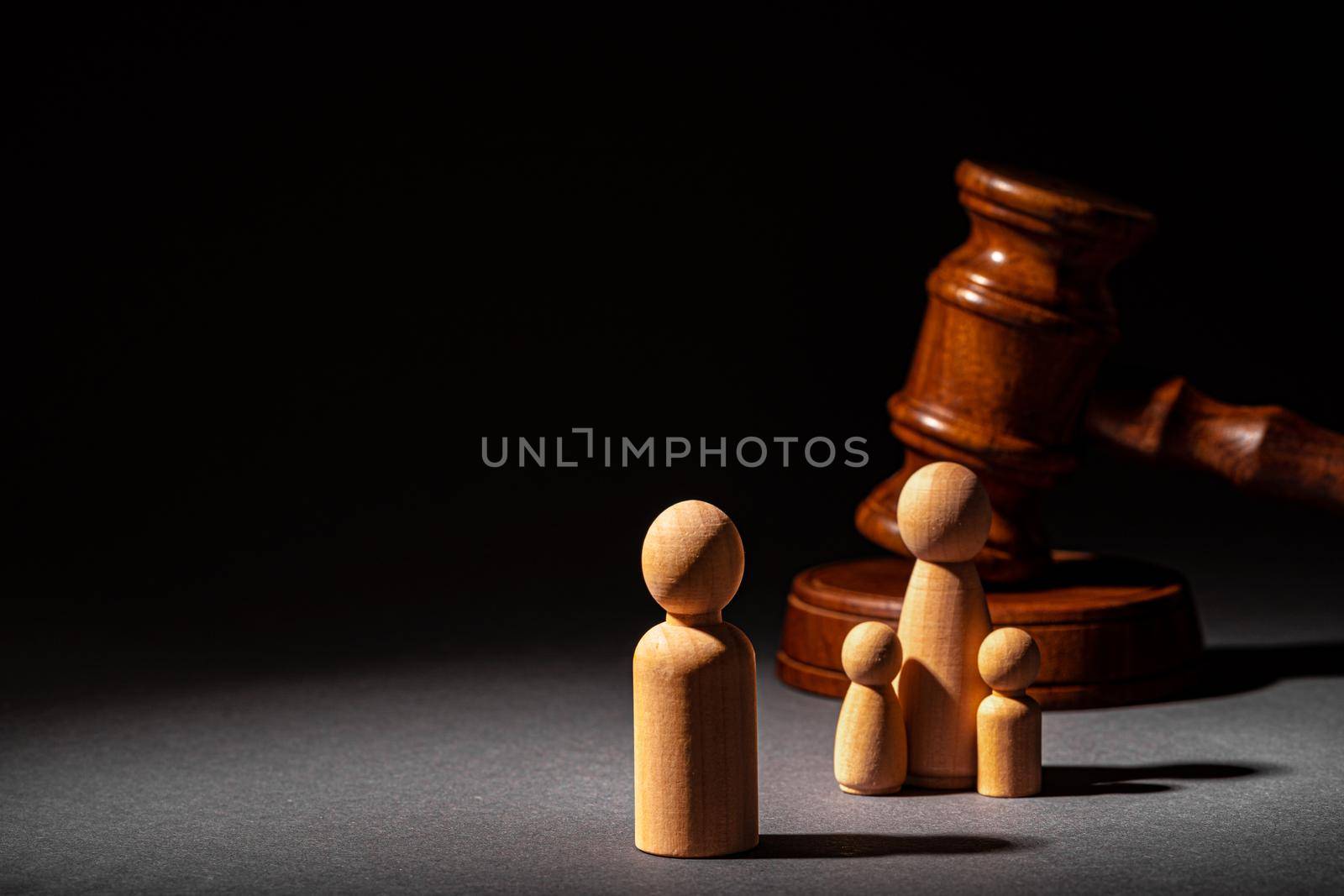 Wooden toy family and judge mallet close up. Family divorce concept