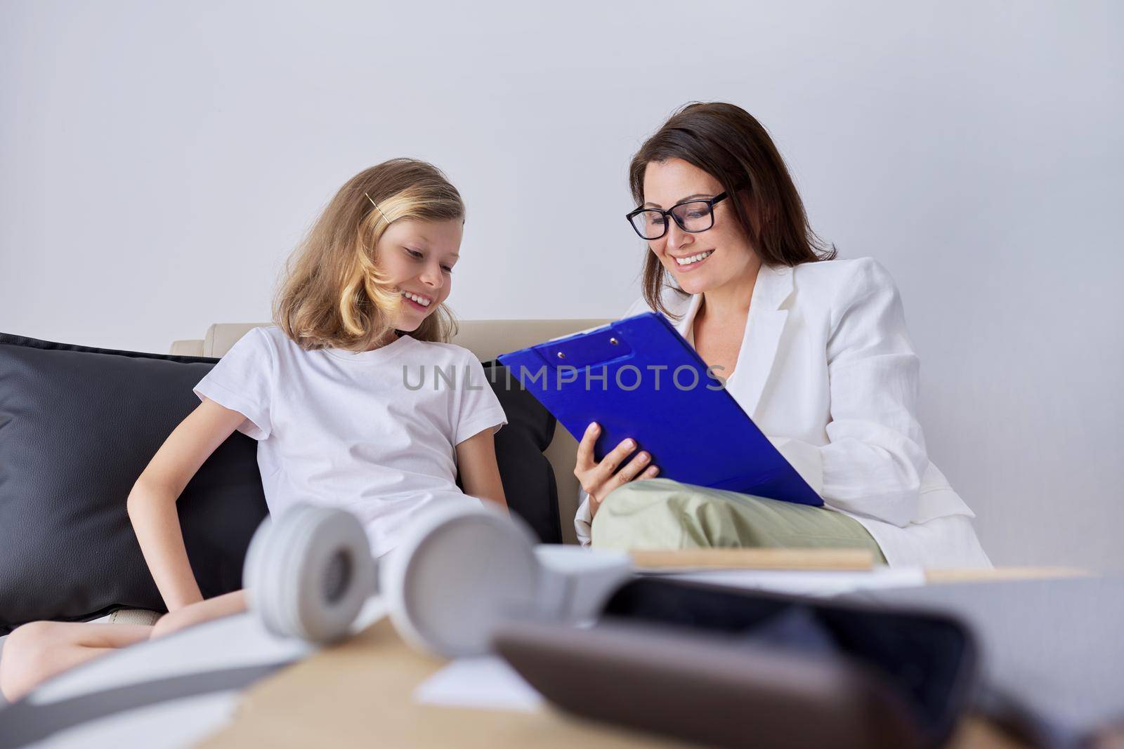 Girl child at session with female psychologist counselor social worker in office. Psychology, therapy, childhood, education, support concept