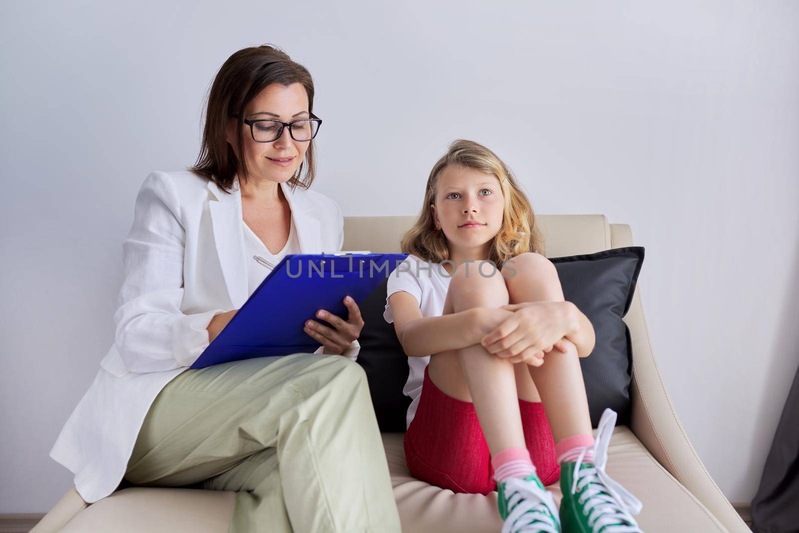 Girl child at session with female psychologist counselor social worker in office. Psychology, therapy, childhood, education, support concept