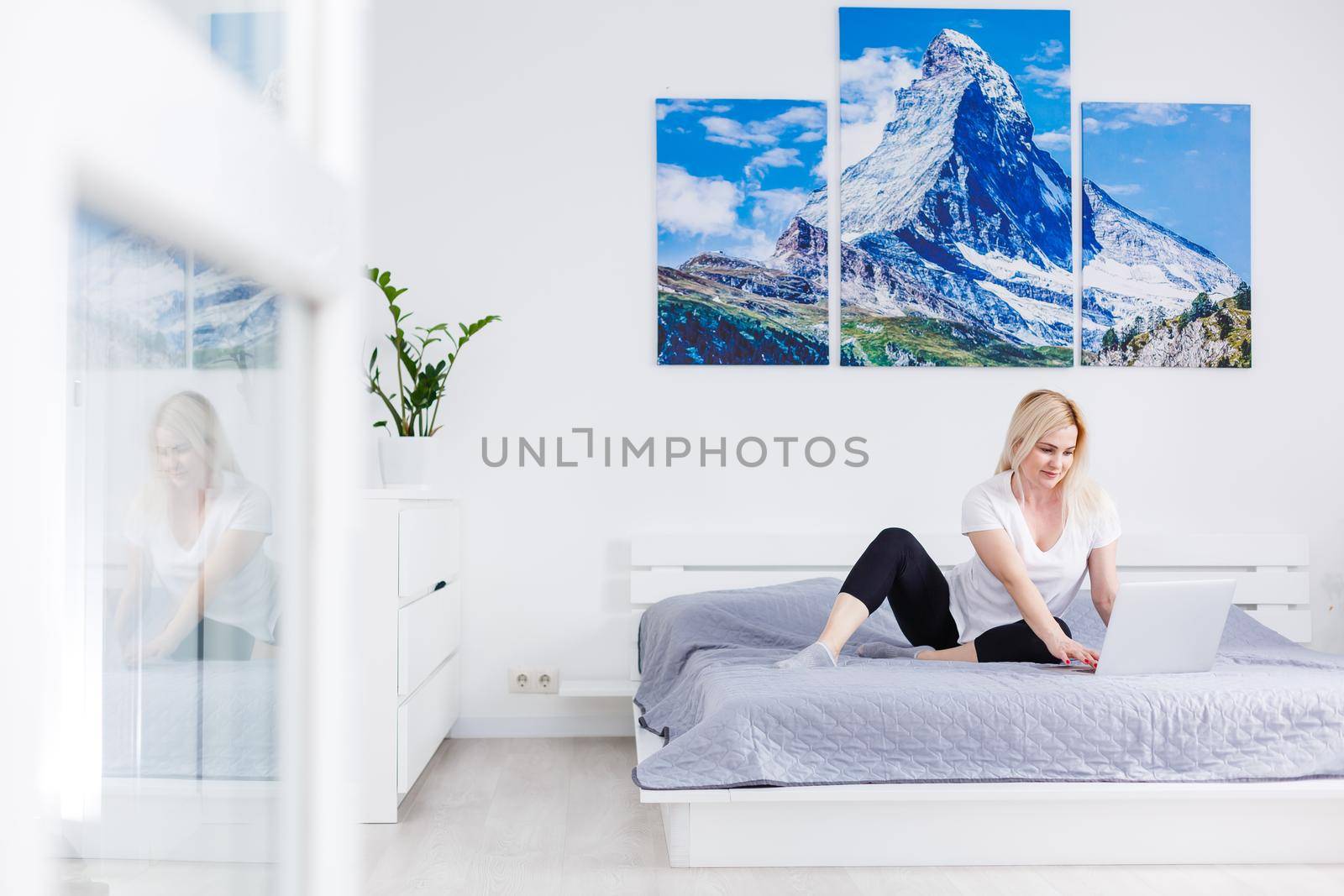 A smiling woman in front of her laptop at home