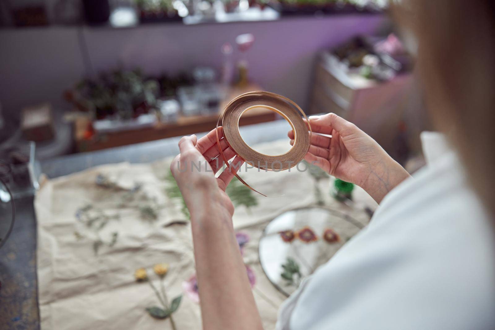 Confident female florist is working with dryed flowers in cozy flower shop