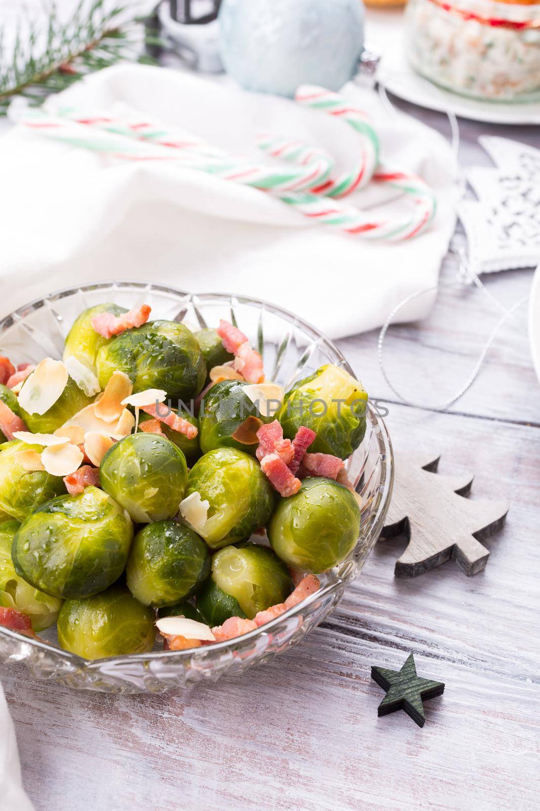 Brussels sprouts with fried bacon and almonds. Delicious Christmas themed dinner table. Holiday concept.