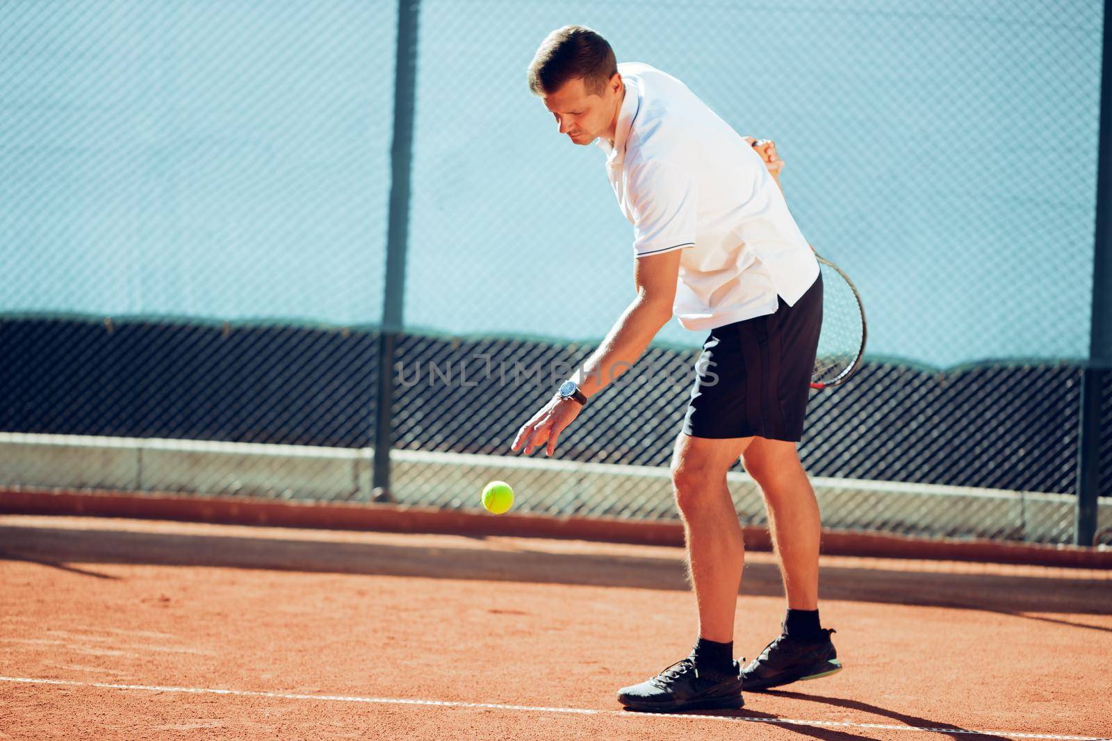 Young proffesional tennis player doing a serve of ball