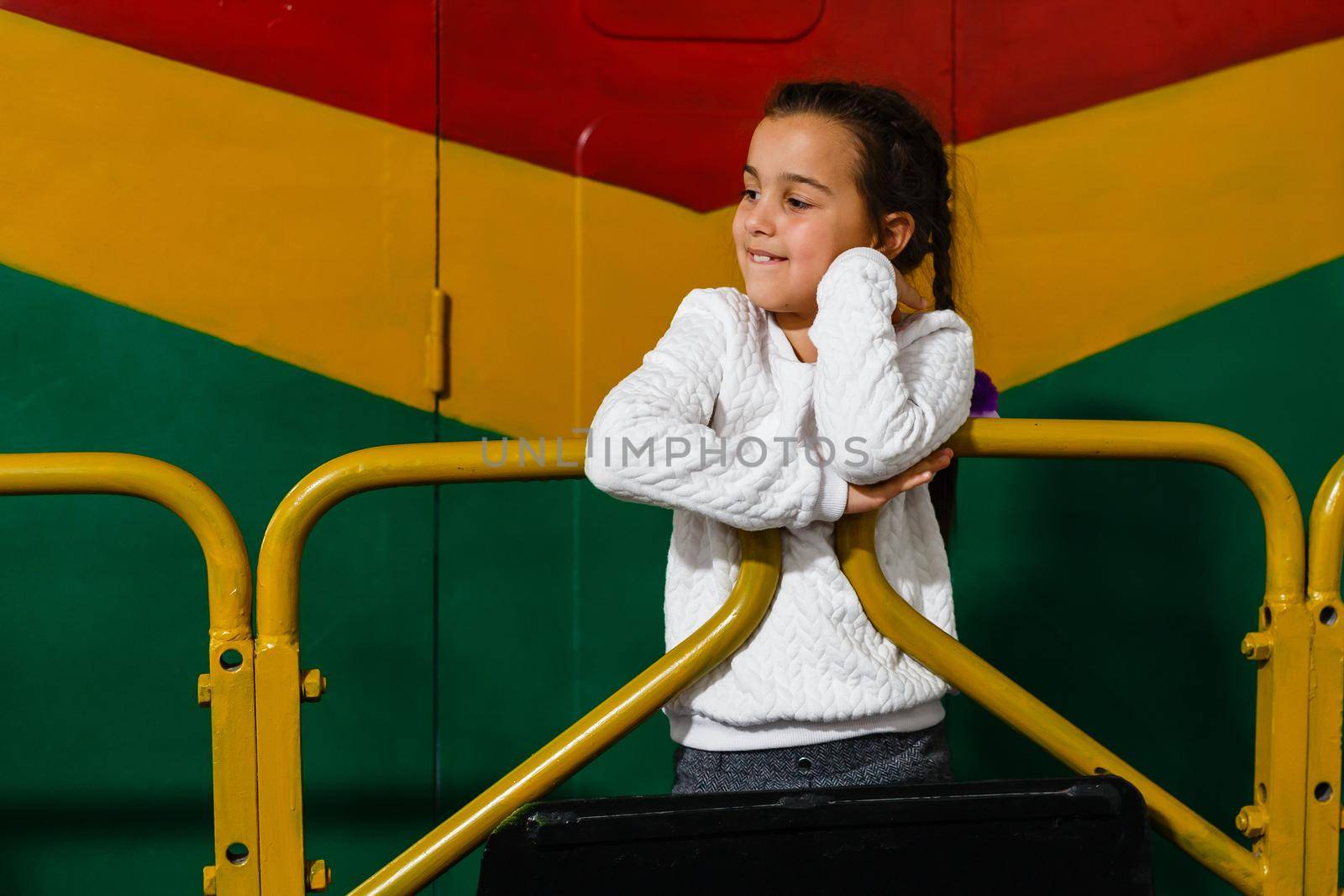 a little girl near a large train carriage.